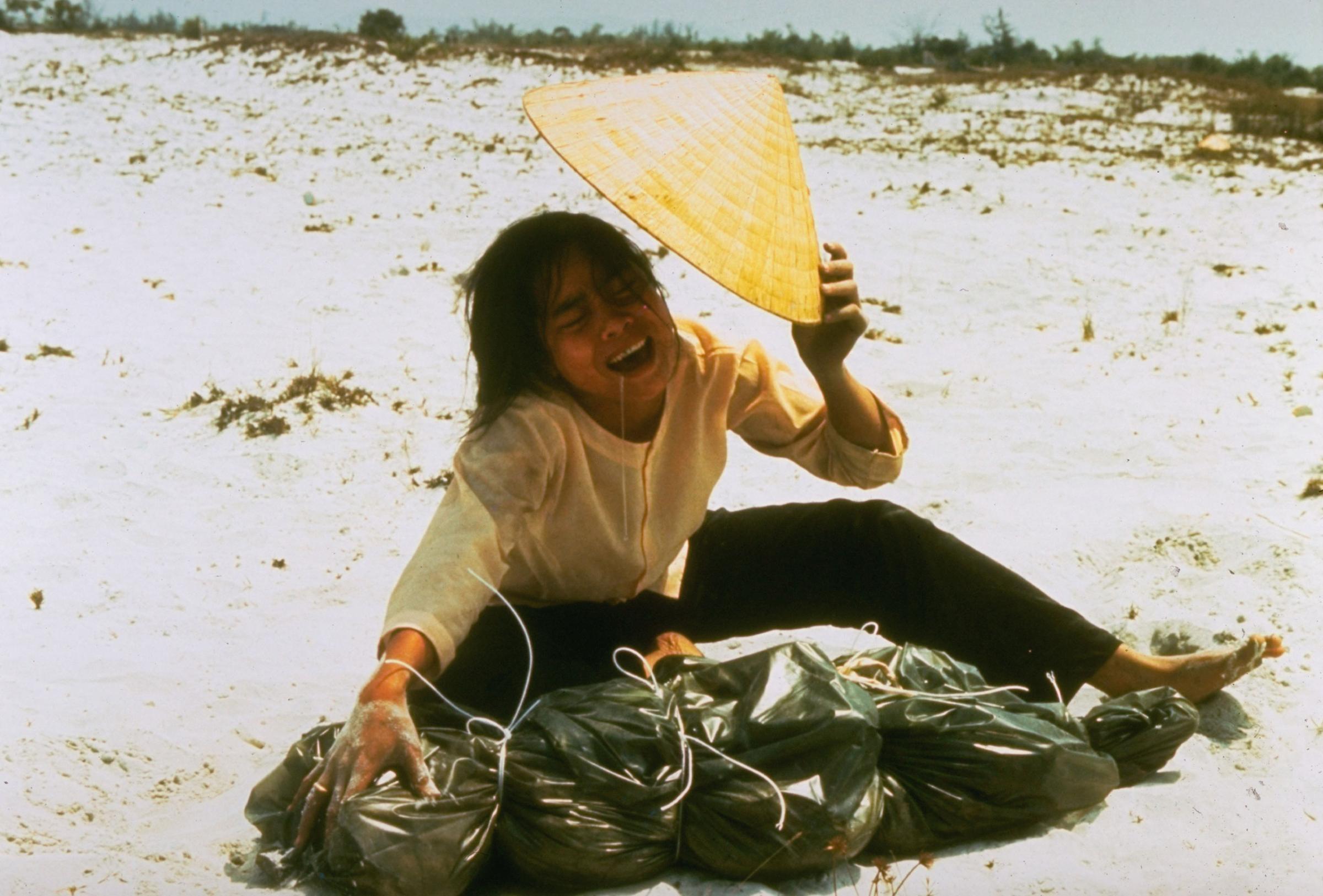 A grieving widow cries over a plastic bag containing remains of her husband which were found in mass grave. He was killed in Feb. 1968 during the Tet offensive.