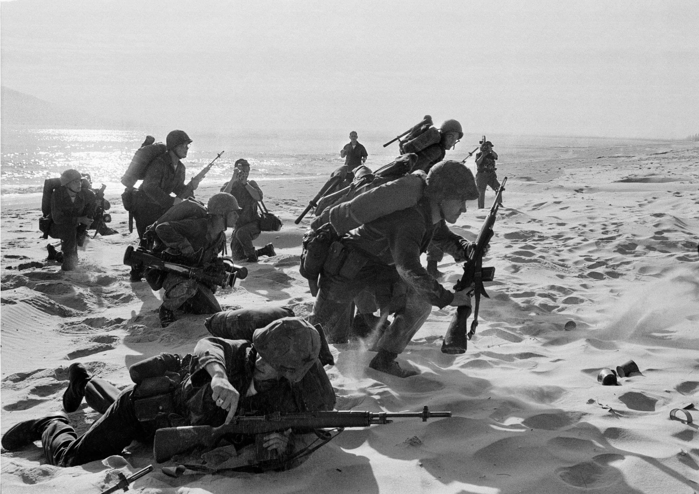 Newly-landed U.S. Marines make their way through the sands of Red Beach at Da Nang, on their way to reinforce the air base as South Vietnamese Rangers battled guerrillas about three miles south, on April 10, 1965.