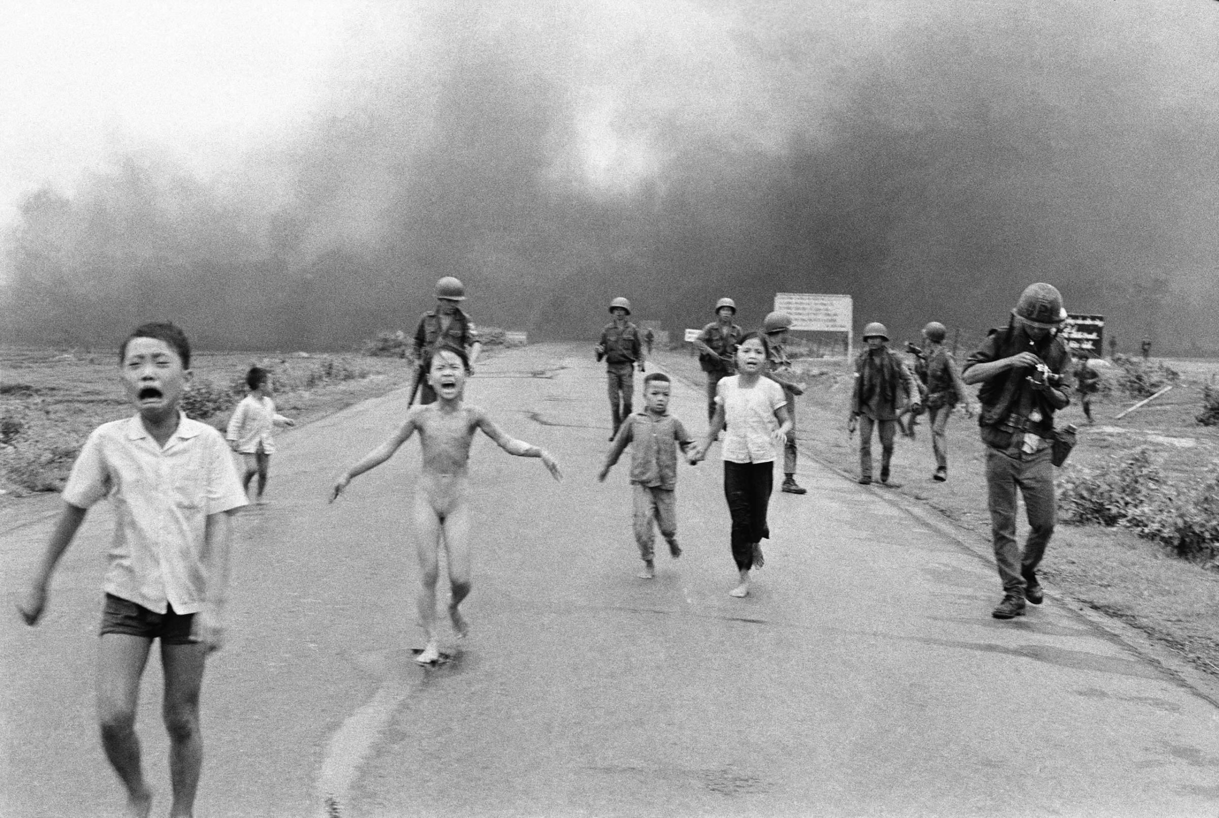 South Vietnamese forces follow after terrified children, including 9-year-old Kim Phuc (center) as they run down Route 1 near Trang Bang after an aerial napalm attack on suspected Viet Cong hiding places on June 8, 1972.