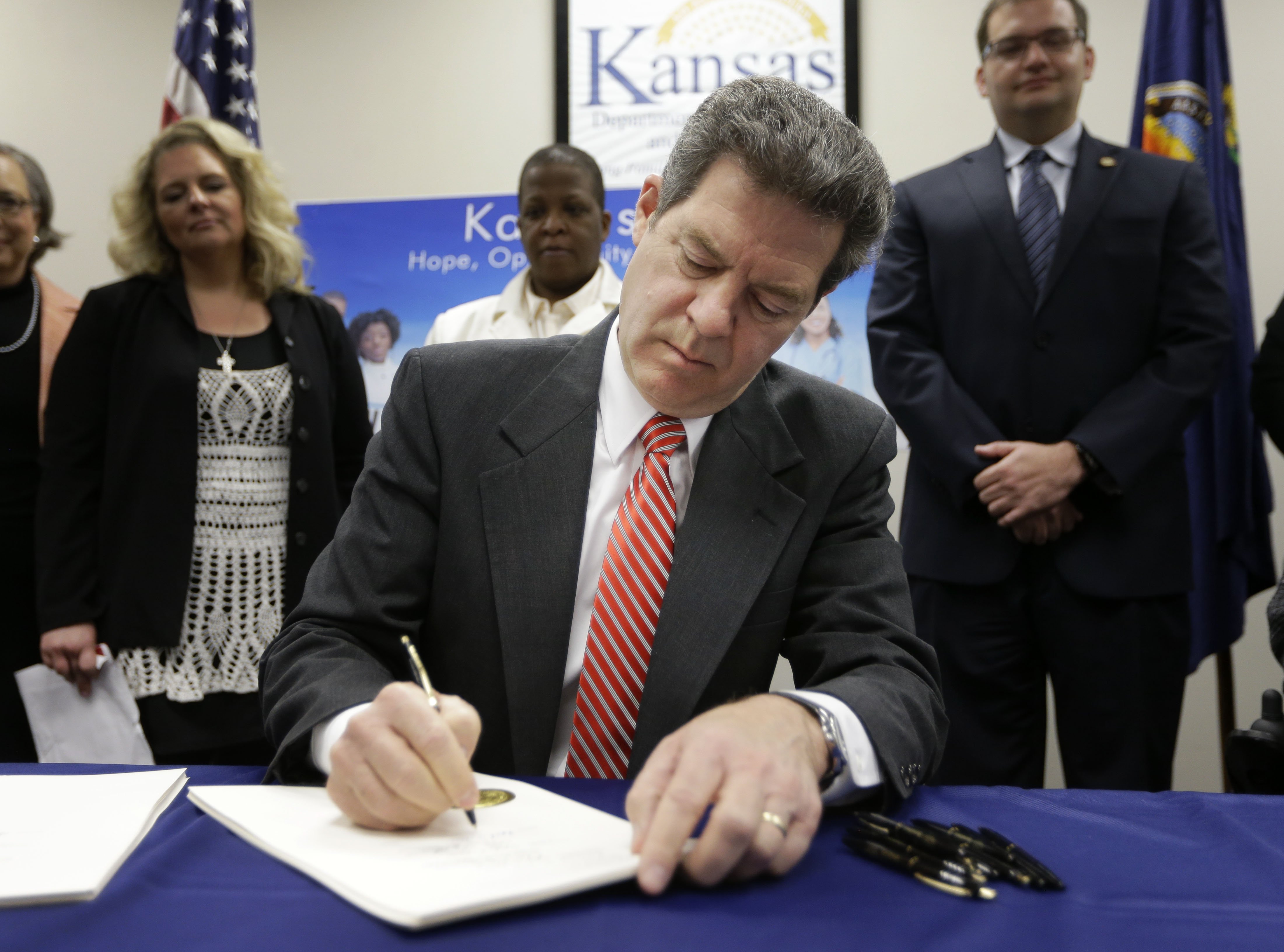 Gov. Sam Brownback signs a welfare reform bill into law in Topeka, Kan. on April 16, 2015.