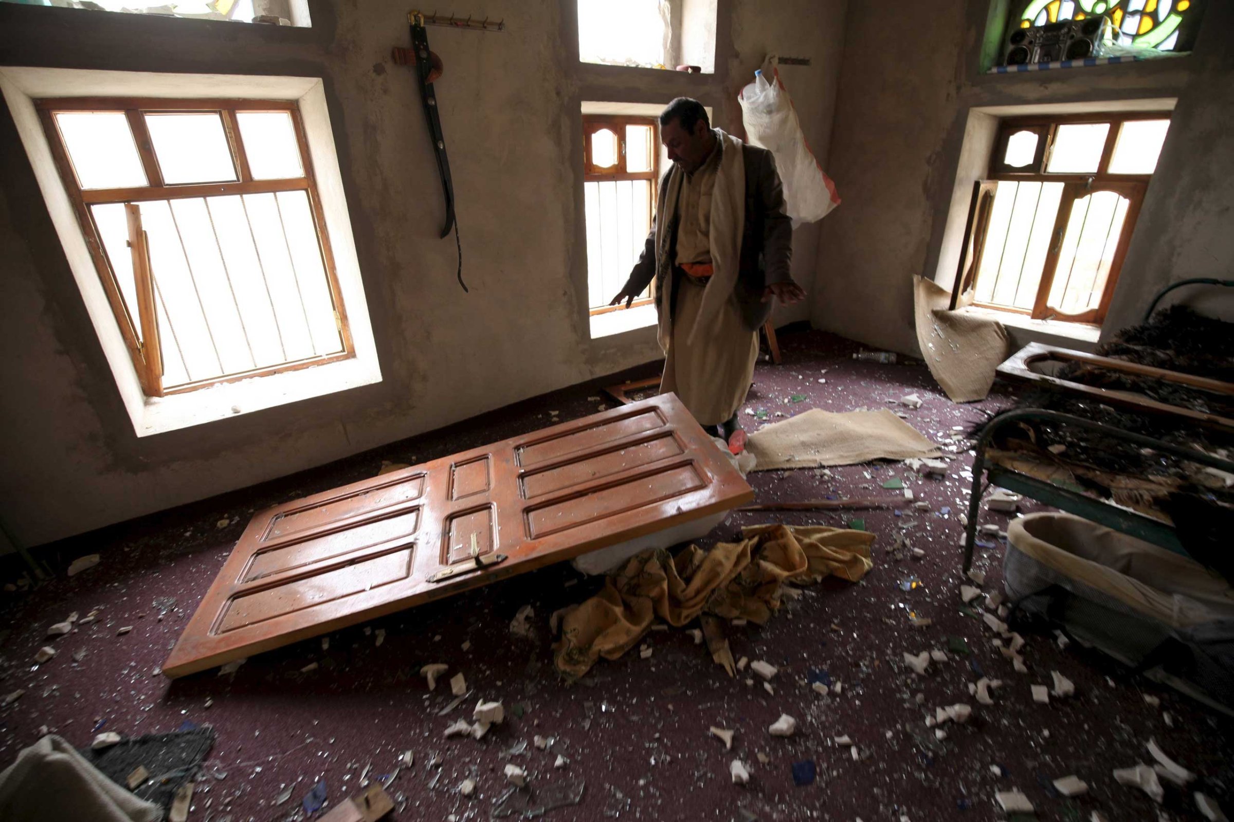A man shows the damage inside his house after an air strike in the Okash village near Sanaa