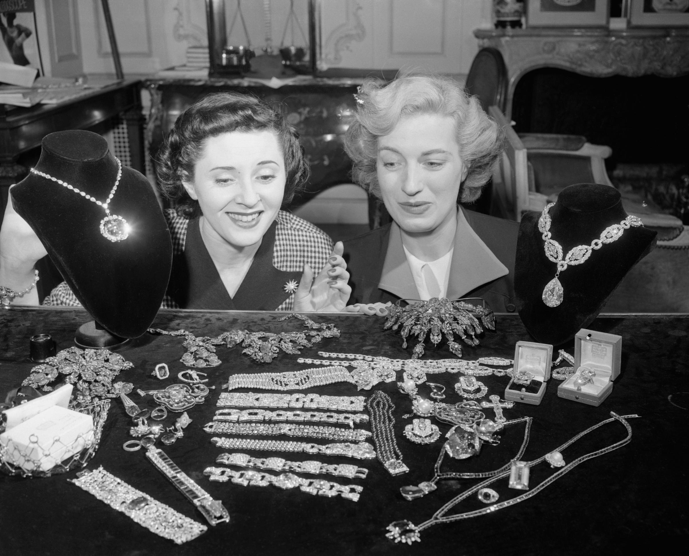 Jill Ciraldo and Grace Flynt are admiring the McLean Jewel Collection at the establishment of Harry Winston, Inc., international jewer dealer, of New York. The Hope Diamond is at left above and the "Star of the East" at right, 1949.