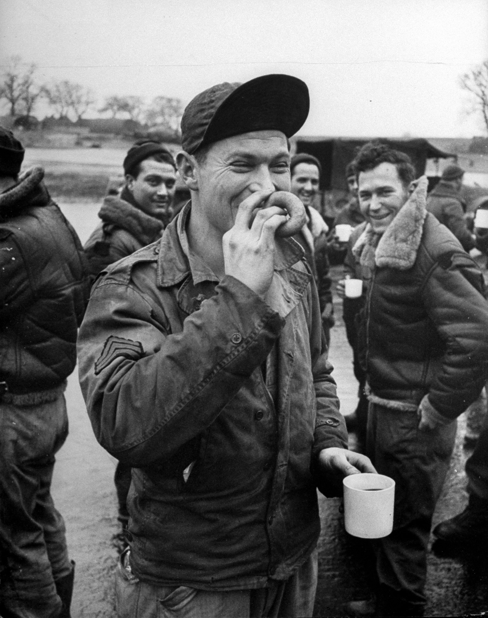 Happy sergeant with doughnut and coffee grins, greets the girls, "Seen ya' com in' a mile away."