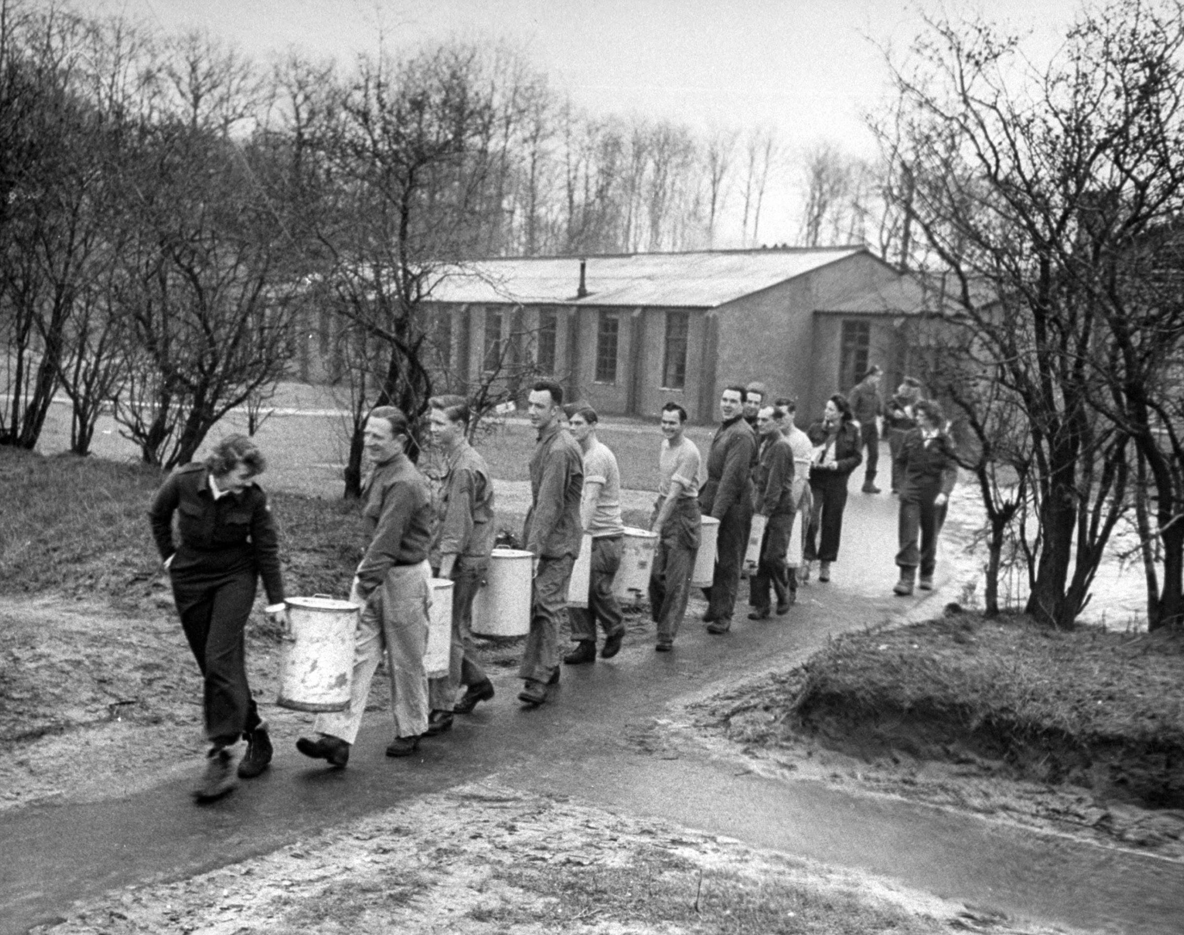 Coffee chain gang trails from mess hall to club mobile. Brew for afternoon's rounds is made in kitchen of base girls are visiting. Eight urns hold 40 gal. of coffee.