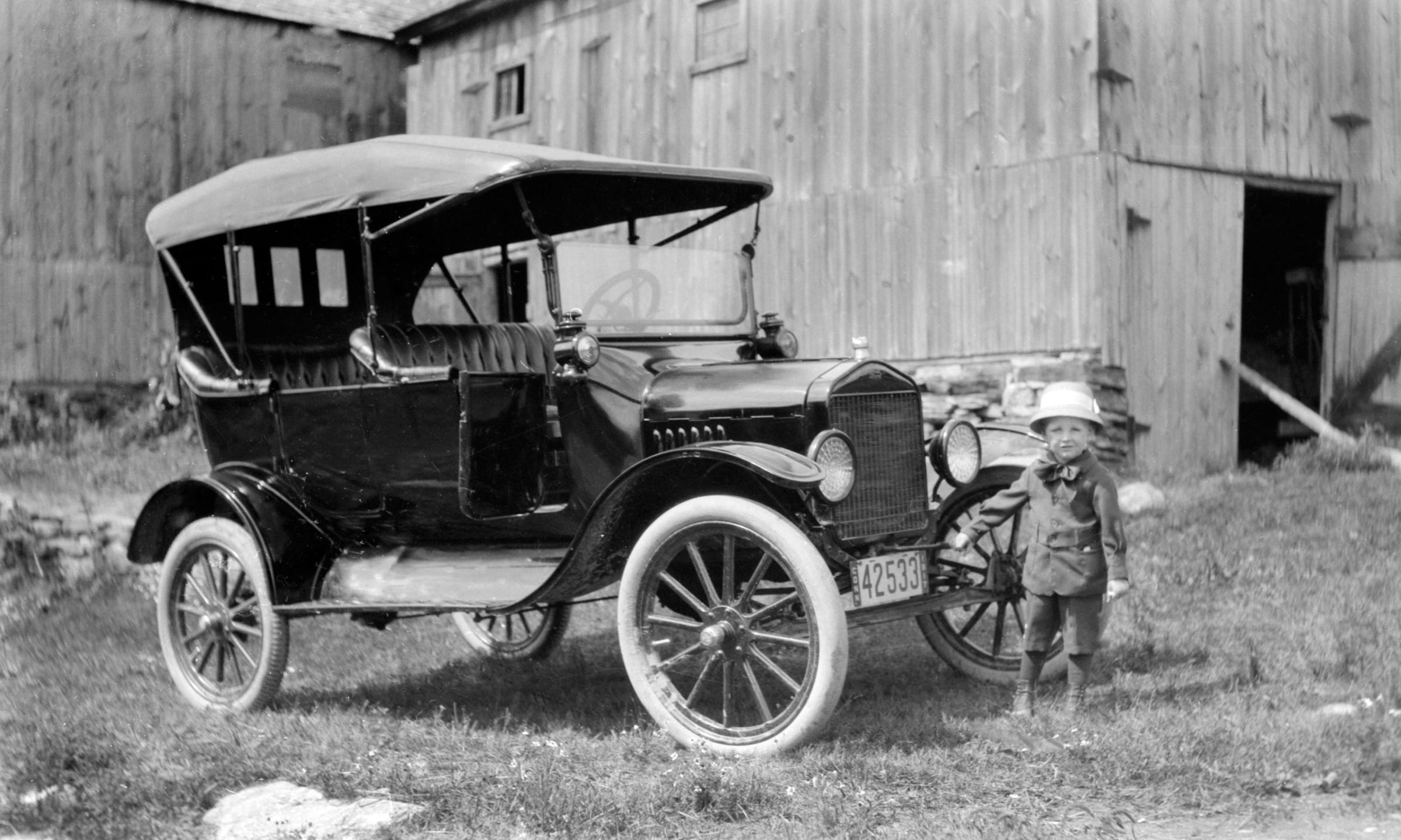 Young boy with the family Model T, on the farm, 1917.