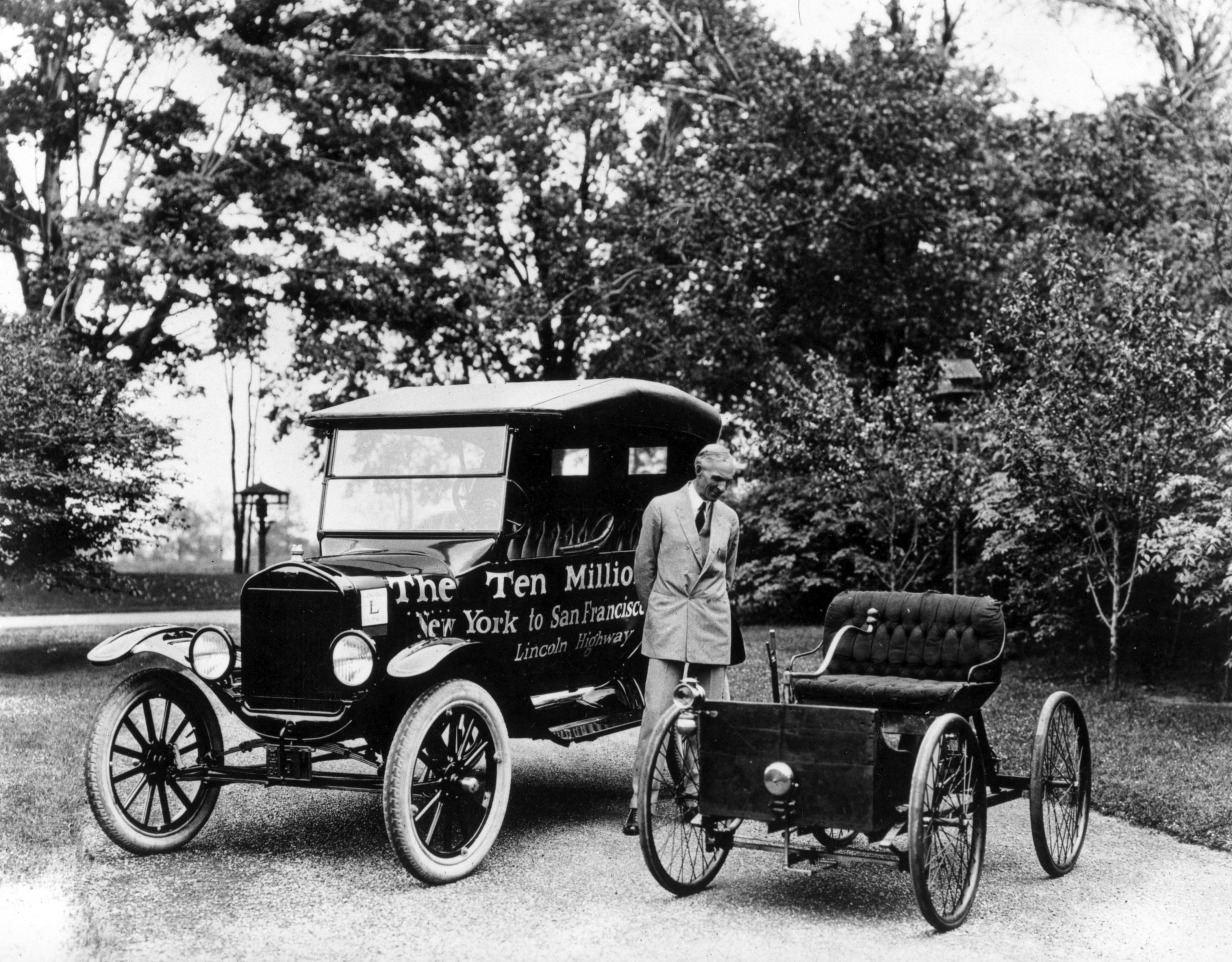 American motor vehicle industry pioneer Henry Ford (1863 - 1947) standing next to the first and the ten millionth Model-T Ford, 1924.