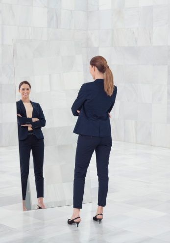 businesswoman-standing-mirror