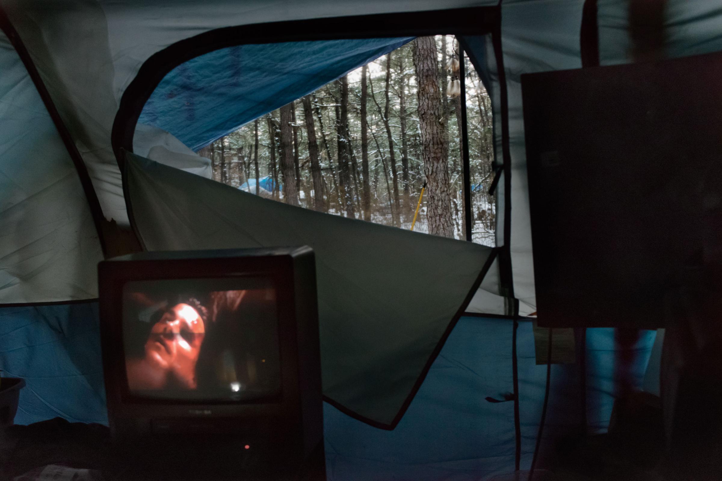 3 March  2014 - Tent City, Lakewood, New Jersey - Residents watch the latest batman film on DVD pwered by a generator. - Christopher Occhicone