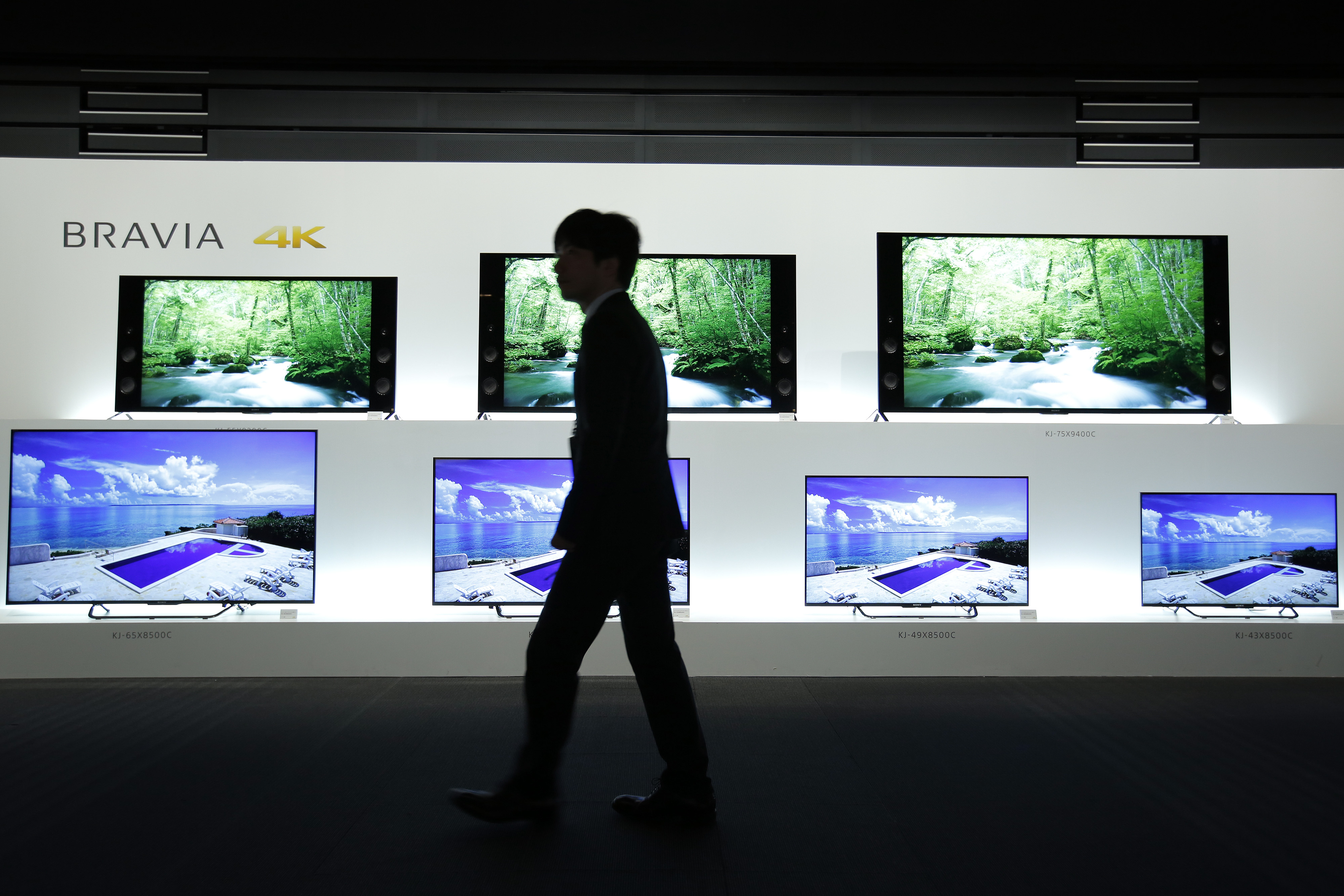 An attendant walks past Sony Corp. Bravia 4K liquid crystal display (LCD) televisions displayed at a launch event in Tokyo, Japan, on Wednesday, May 13, 2015. (Bloomberg&mdash;Bloomberg via Getty Images)