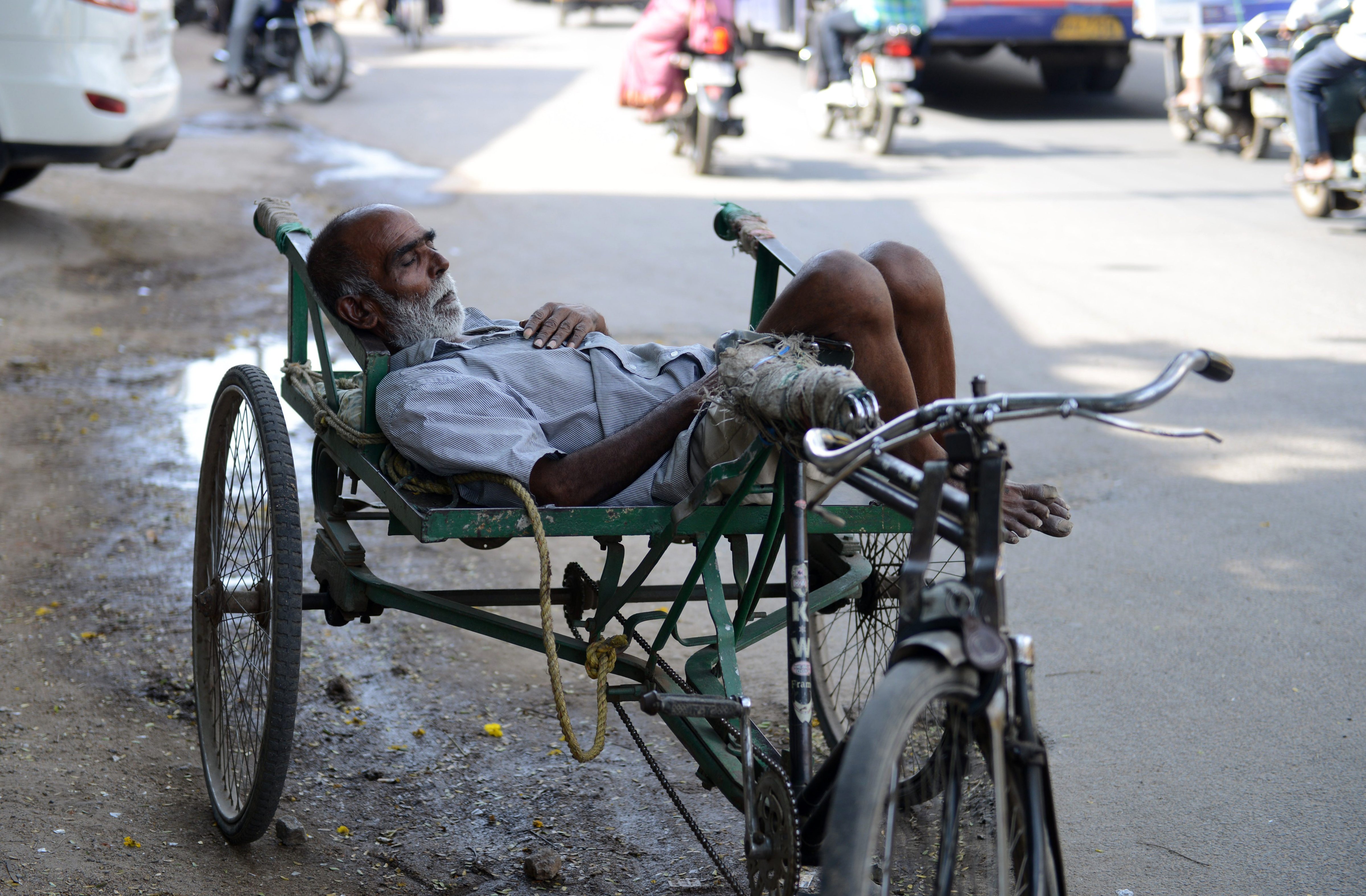An Indian resident sleeps in the shade on a tricyle at the roadside in Hyderabad on May 22, 2015 (Noah Seelam—AFP/Getty Images)