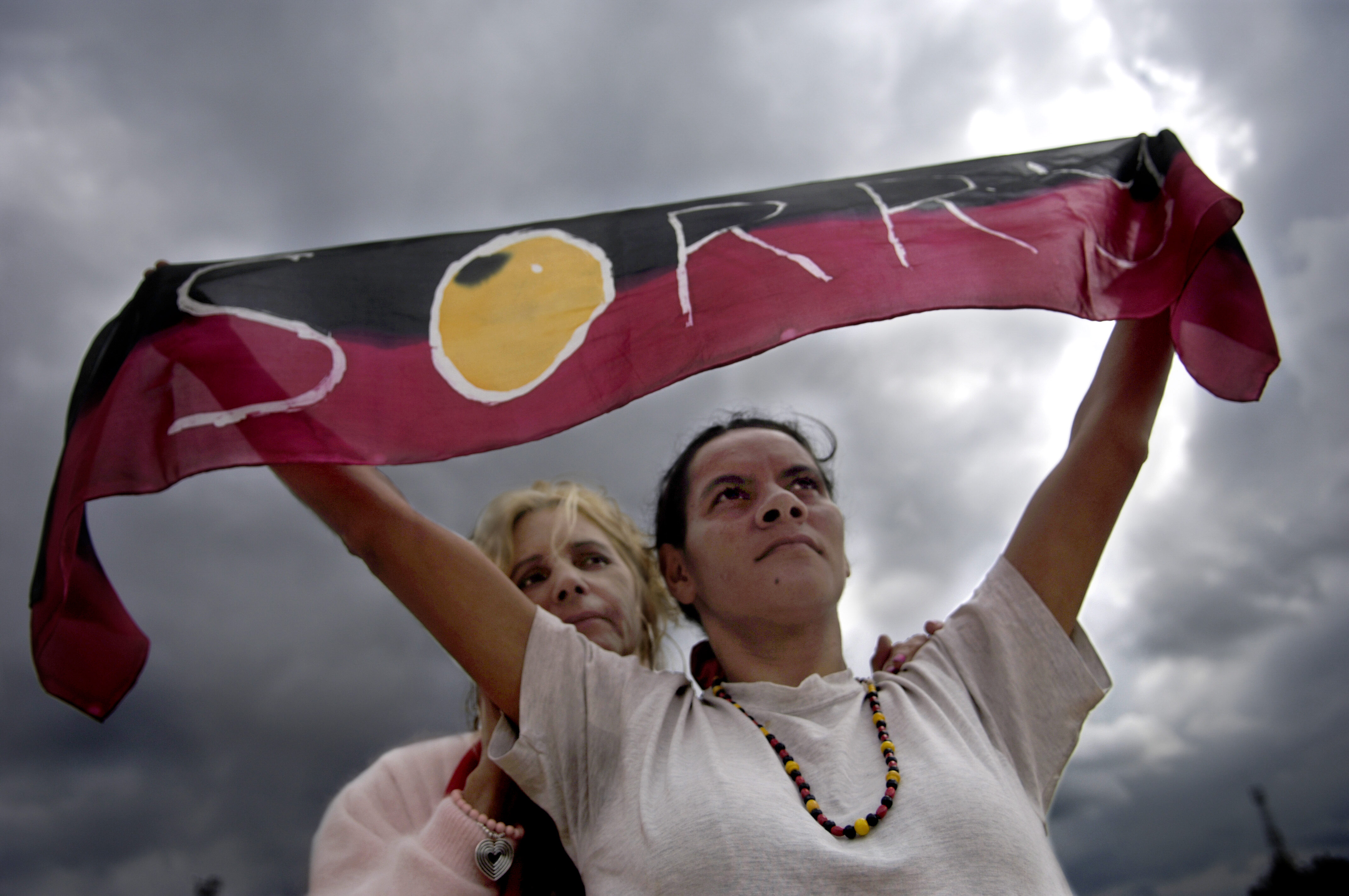 Rhonda Randall and Sharon Mumbler stand proud with their "Sorry" scarf as  Kevin Rudd's Broadcast apology to Aboriginal Peoples of Australia at Penrith Council on February 13, 2008 in Penrith, Australia. (Newspix—Newspix via Getty Images)