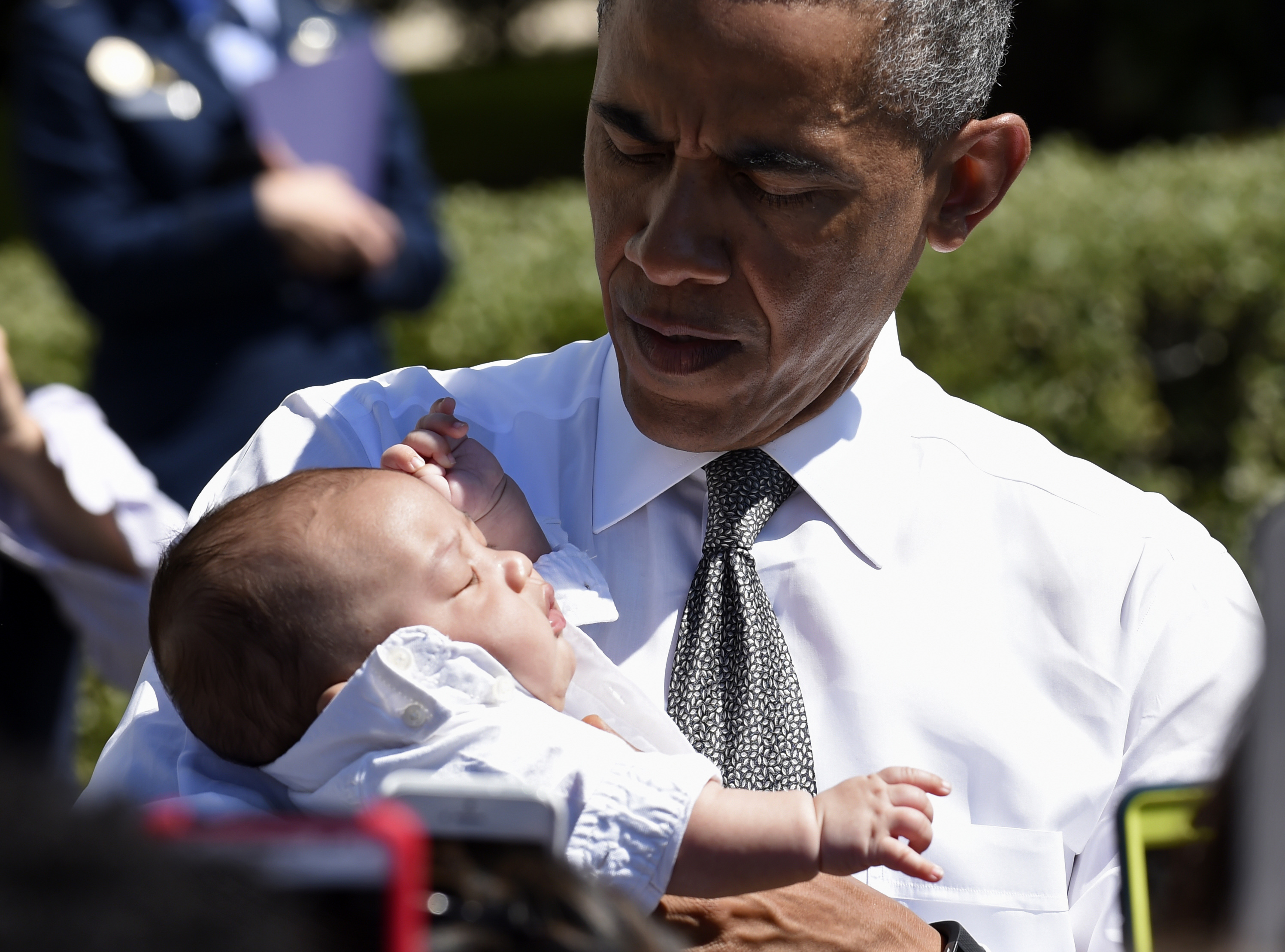 President Barack Obama holds a baby as he greets guests attending an event at the White House in Washington on April 16, 2015. (Susan Walsh&mdash;AP)