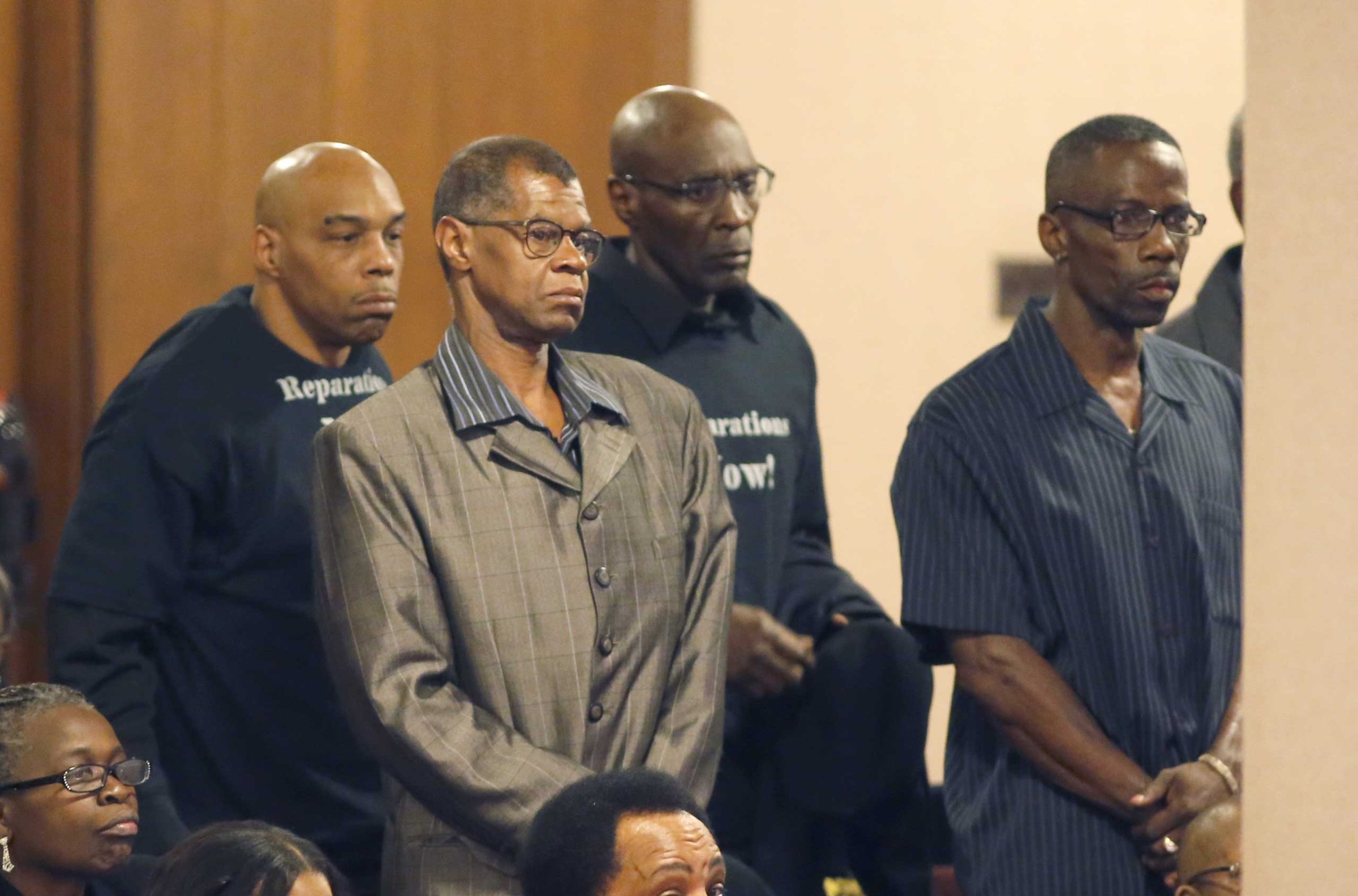 Men identified as victims of police torture under the command of retired Chicago Police Commander Jon Burge, stand to be recognized by the Chicago City Council city council, May 6, 2015, in Chicago.