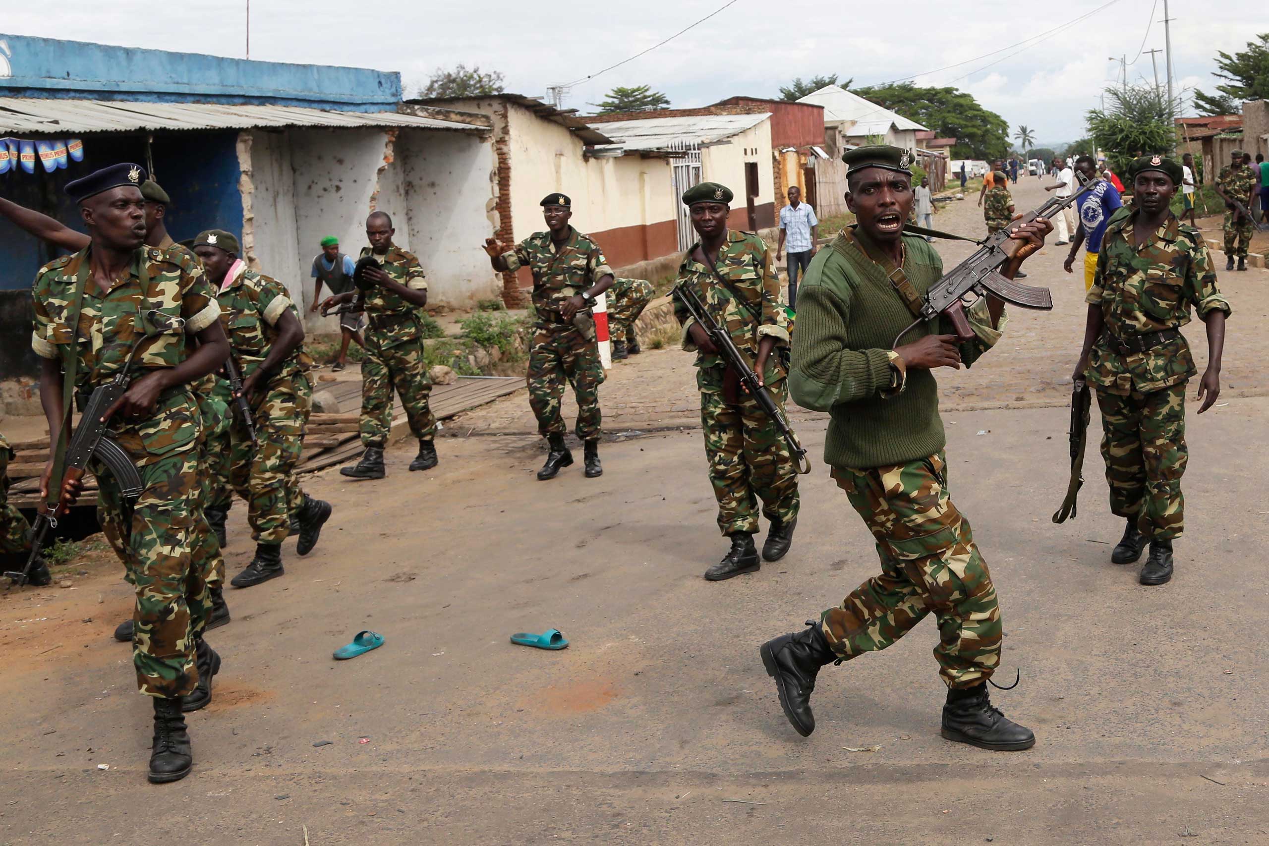 Soldiers disperse a crowd by firing into the air after demonstrators cornered Niyonzima in a sewer.