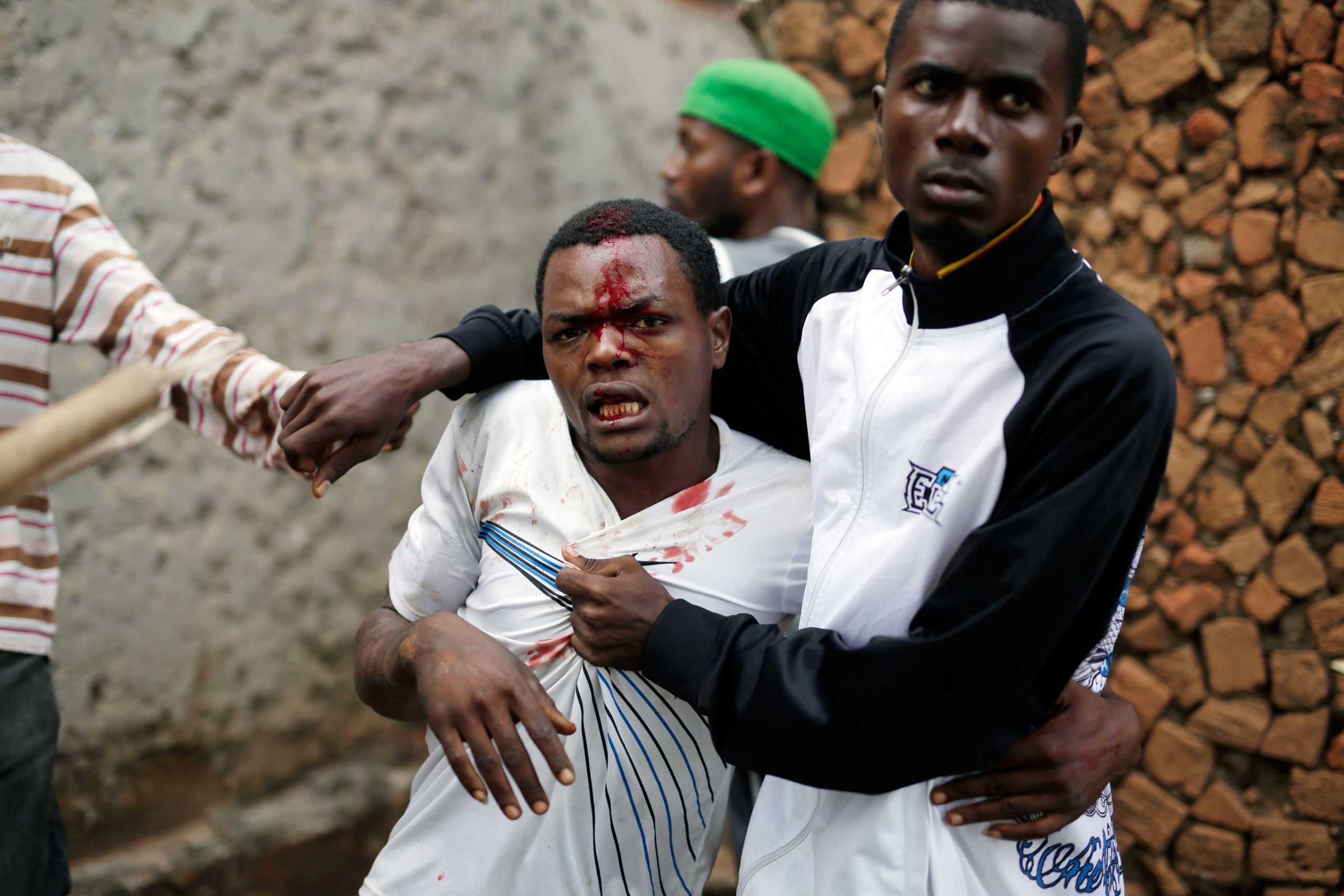 Jean Claude Niyonzima, a suspected member of the ruling party's Imbonerakure youth militia, is restrained as a mob gathers around his house, as protests continue against President Pierre Nkurunziza's decision to seek a third term in office in the Cibitoke district of Bujumbura, Burundi on May 7, 2015.