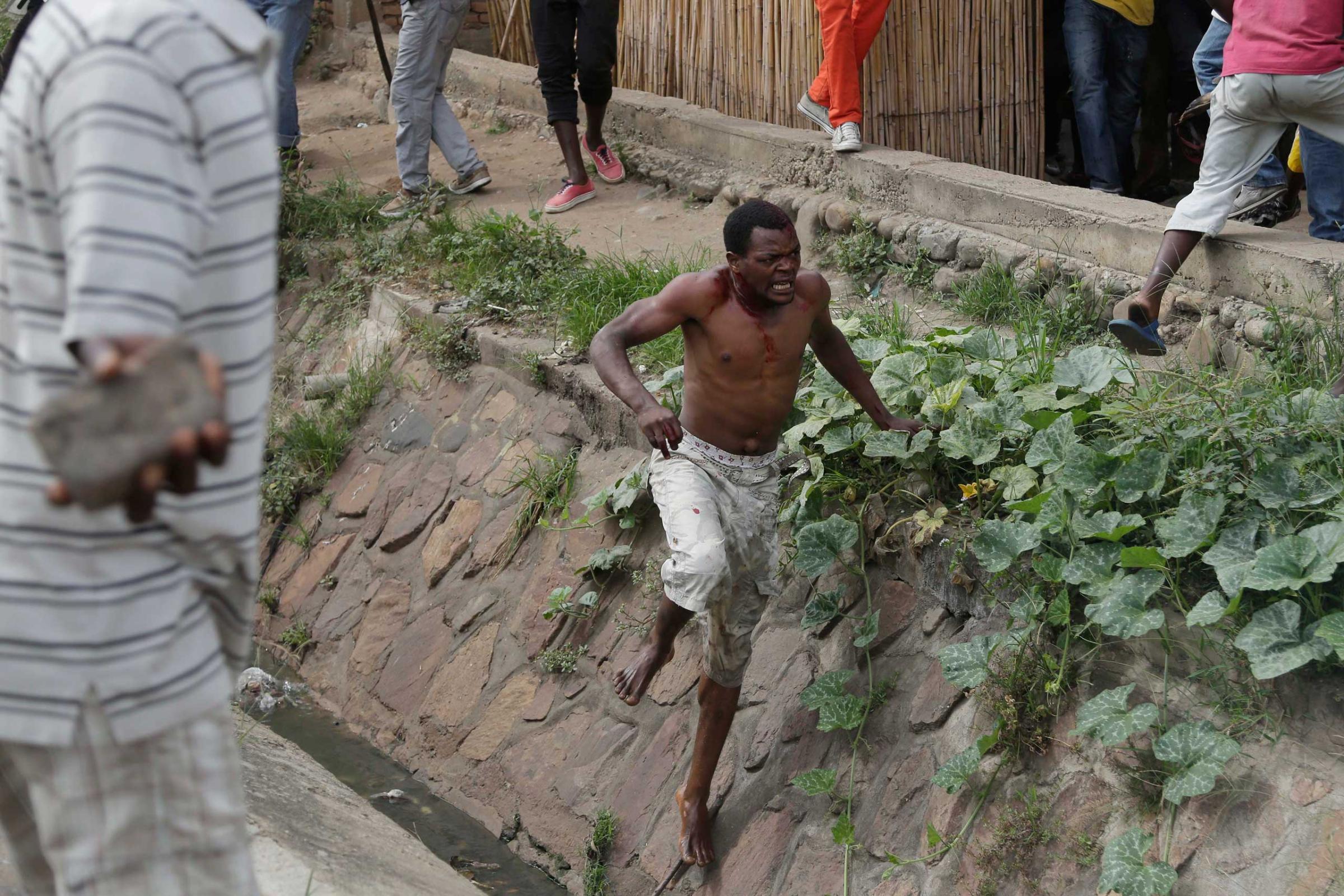 Niyonzima flees from his house into a sewer under a hail of stones thrown by a mob.