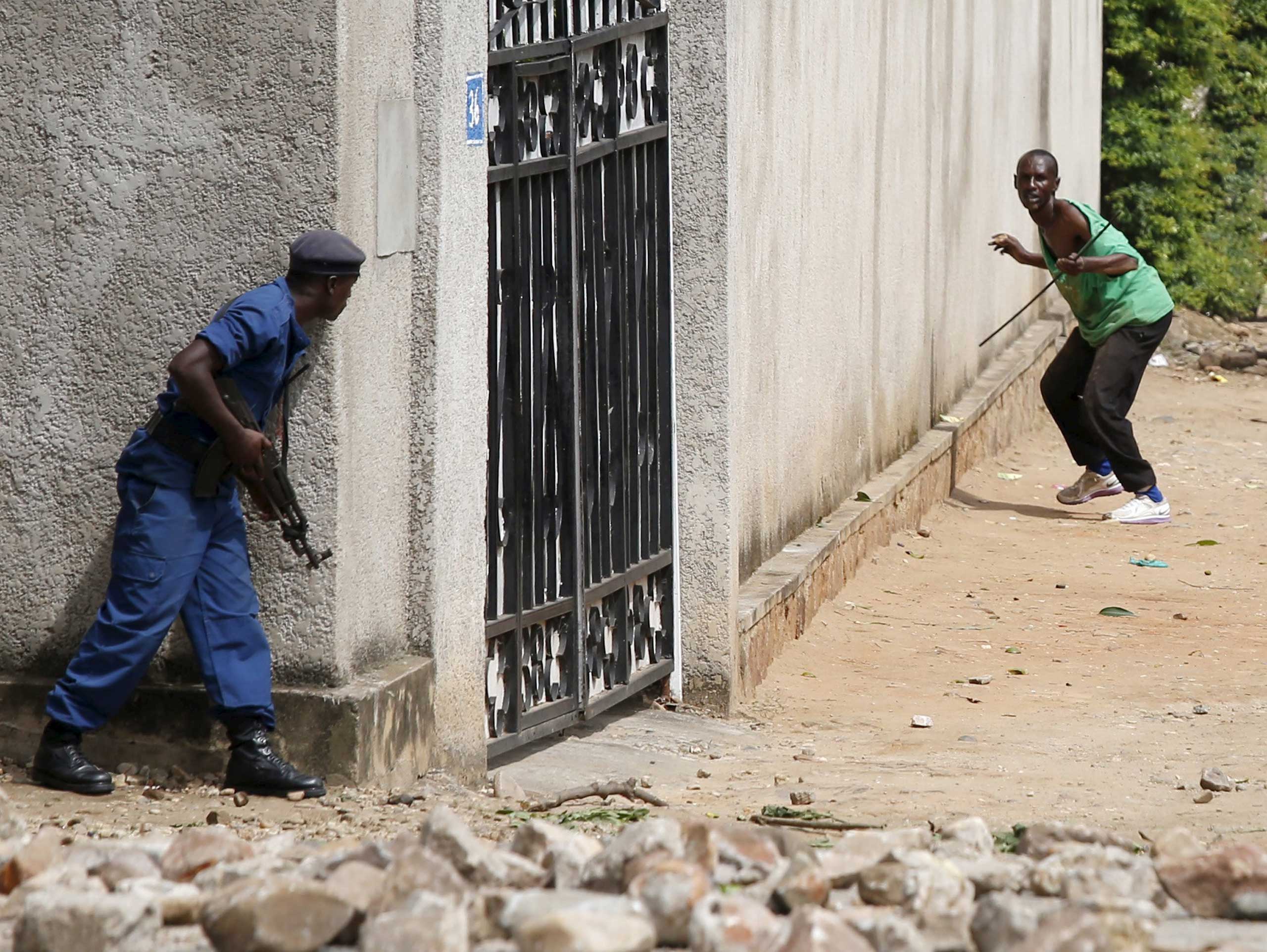 Policemen clash with protesters near a parliament building during a protest against President Pierre Nkurunziza's decision to run for a third term in Bujumbura, Burundi, on May 13, 2015.