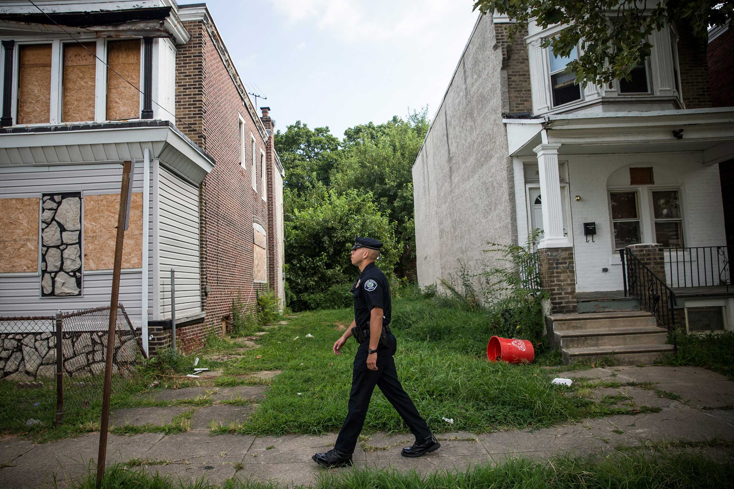 Officer Adam Fulmore, of the Camden County Police Department, goes on a foot patrol in the Parkside neighborhood of Camden, N.J. on Aug. 22, 2013.