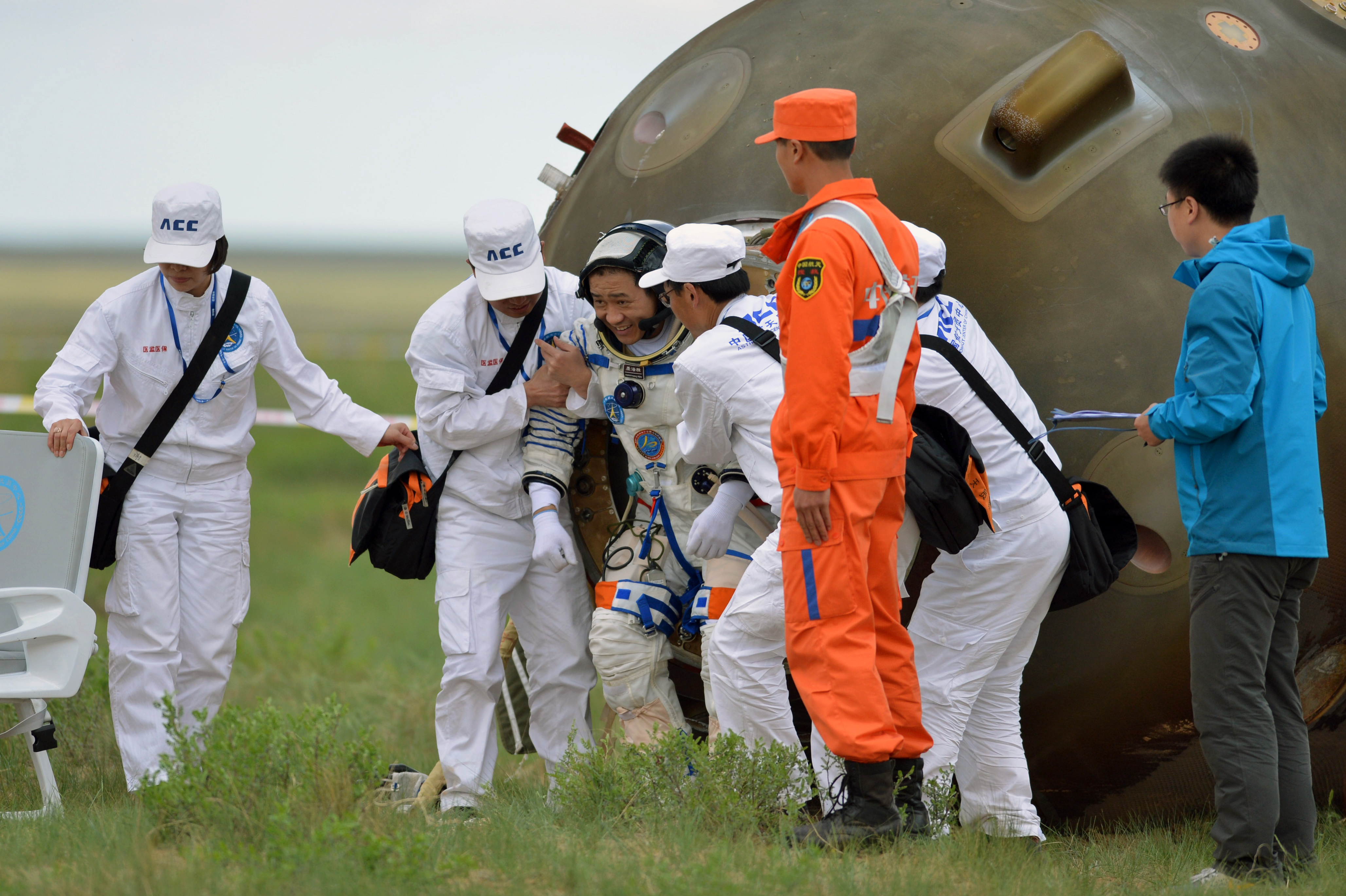 Welcome home: Nie Haisheng is helped out of his Shenzhou 10 spacecraft after a 15-day mission in 2013. (AFP/Getty Images)