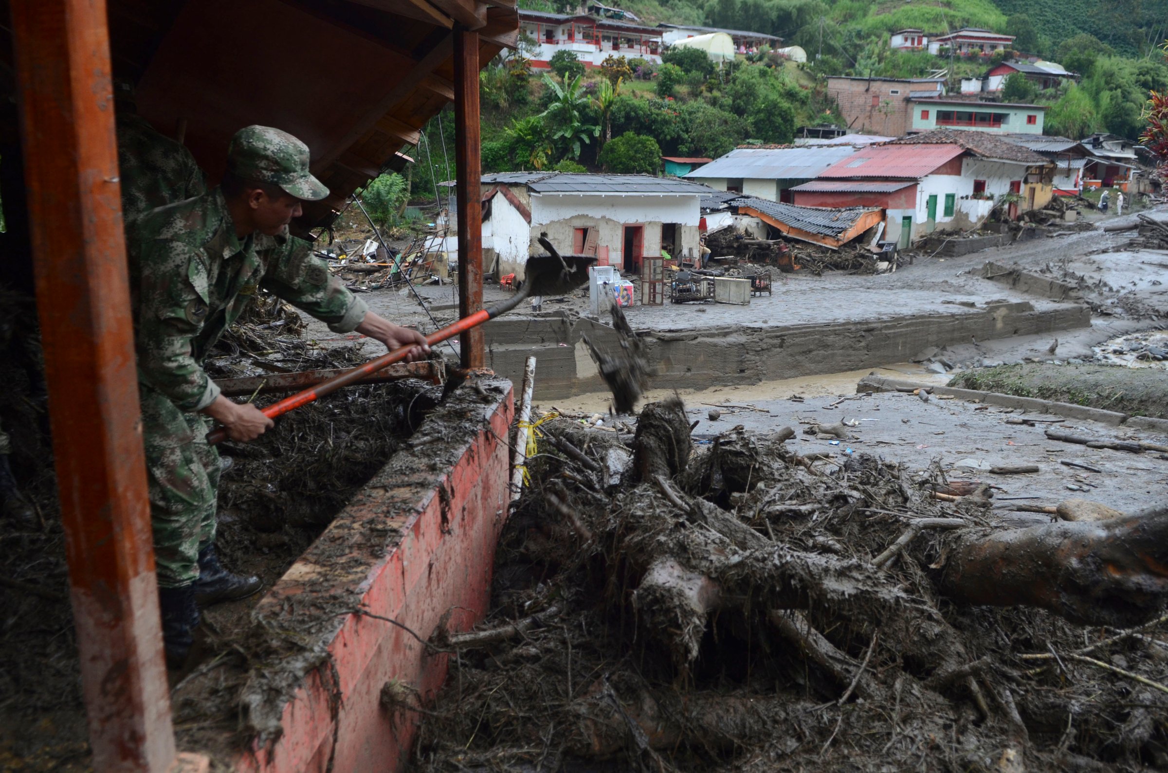 A soldier shovels mud from a house damaged by a mudslide in Salgar, in Colombia's northwestern state of Antioquia, May 19, 2015.