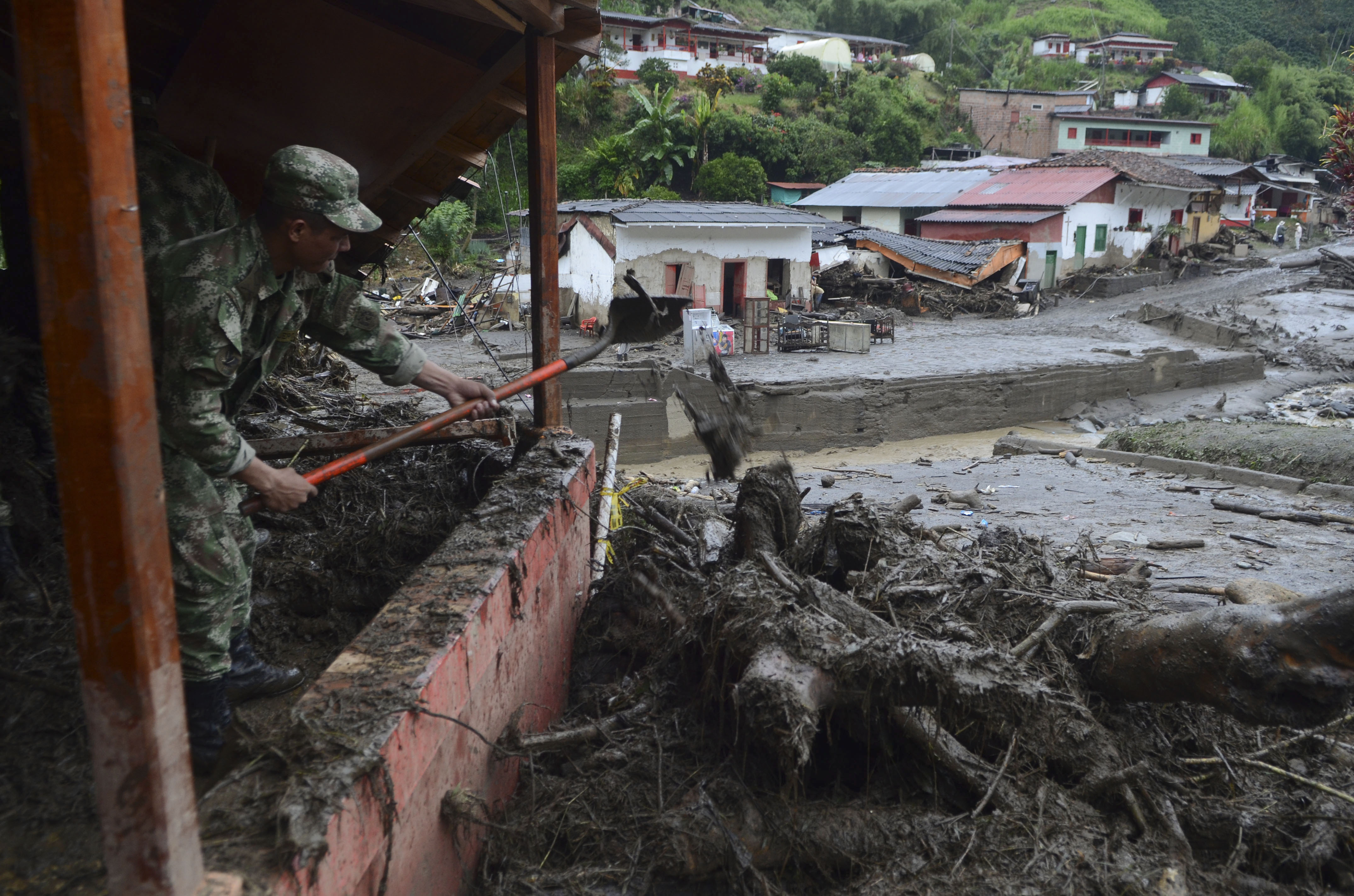 A soldier shovels mud from a house damaged by a mudslide in Salgar, in Colombia's northwestern state of Antioquia, May 19, 2015. (Luis Benavides—Associated Press)