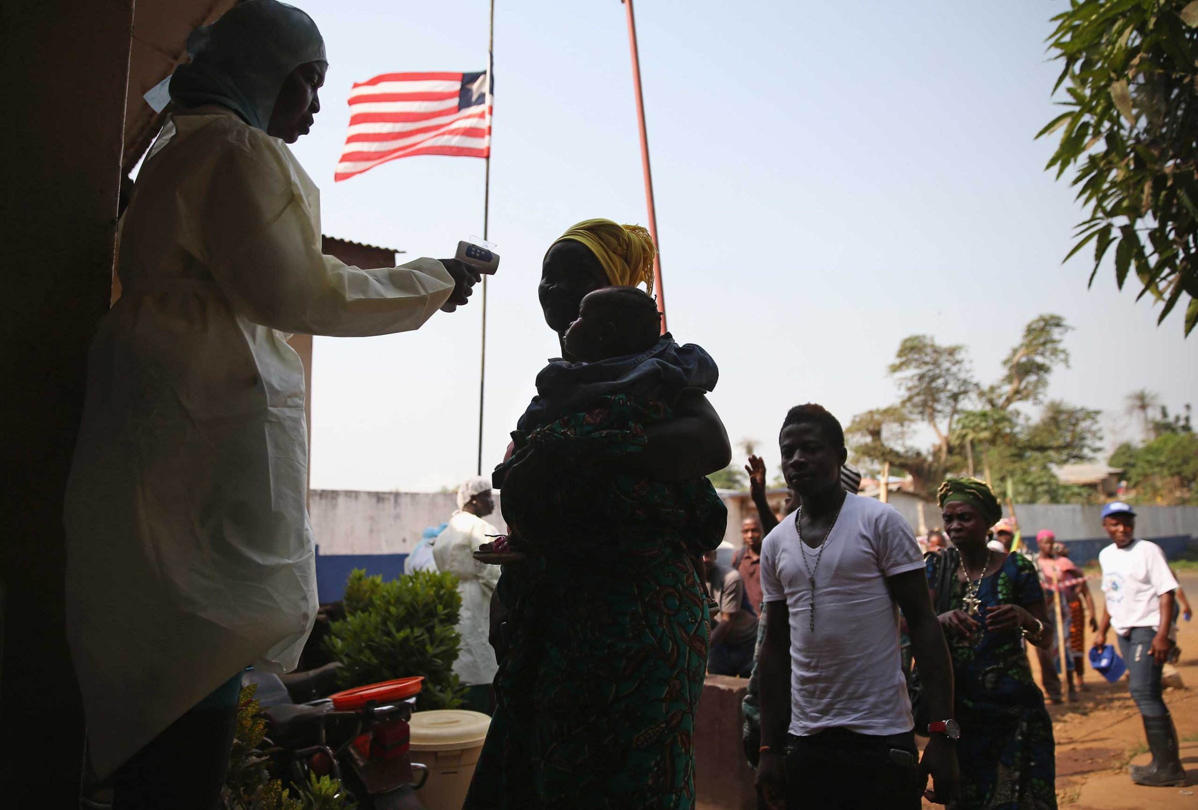 A health worker takes the temperature of a travelers at a highway checkpoint in Liberia on on Jan. 29, 2015.