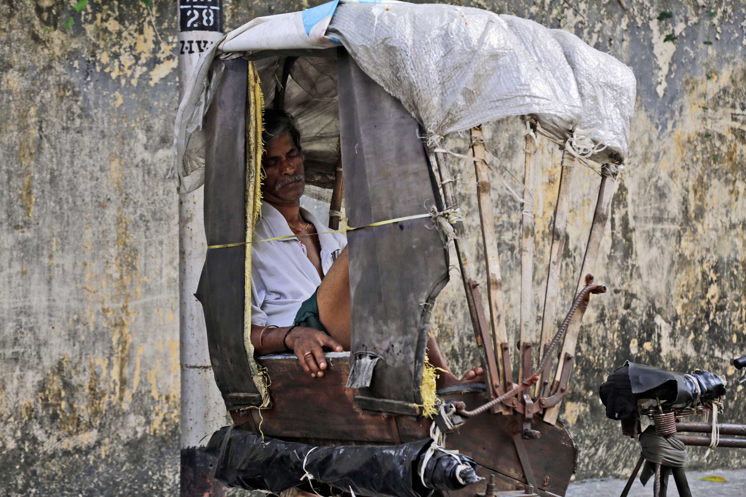 A rickshaw puller rests on a hot summer day in Kolkata, India on May 27, 2015.