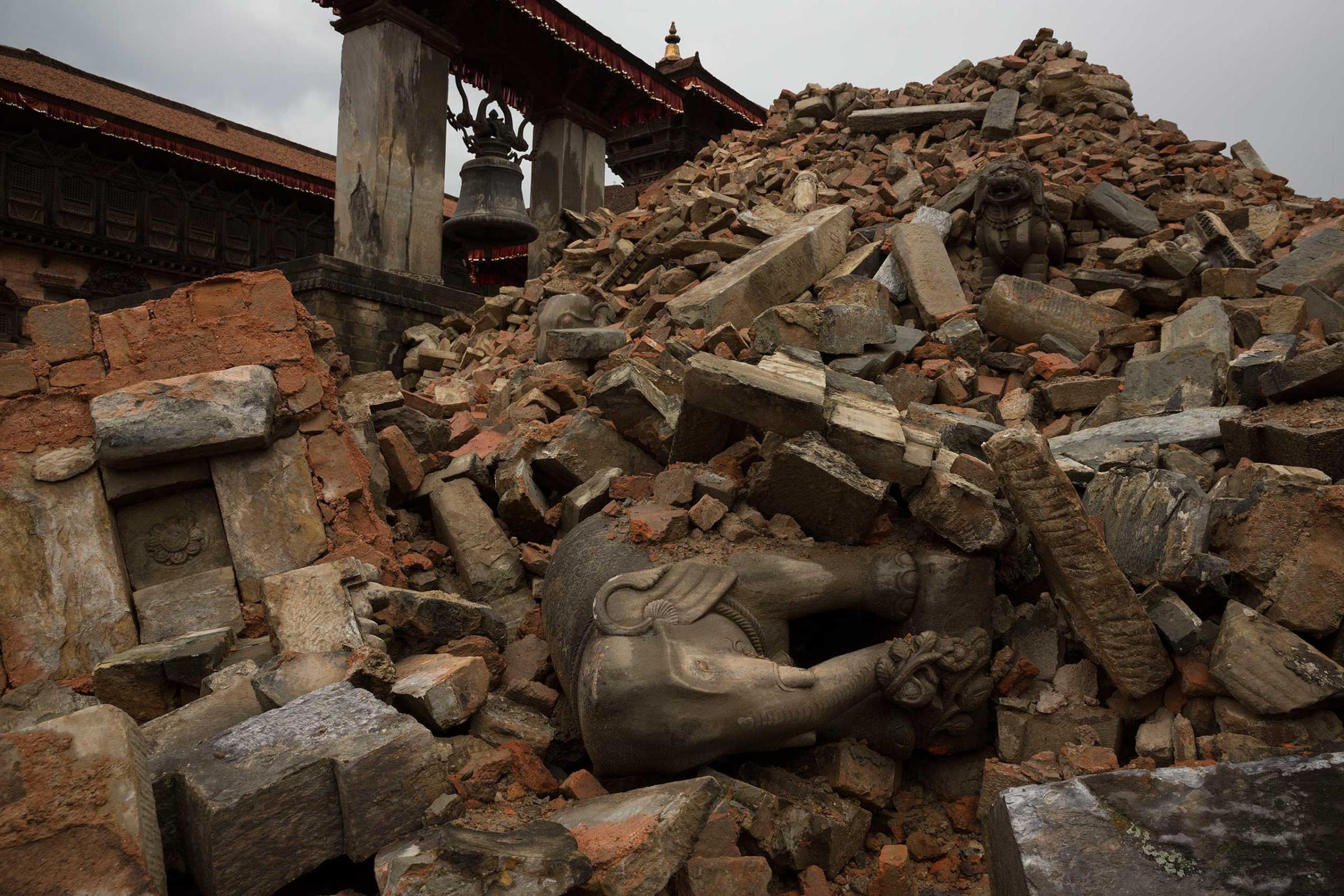 Nepal earthquake. Bhaktapur. A city near Katmandu. People reclaiming their possessions from the wreckage. A man who had been buried and died being pulled out of the wreckage by there Nepali Army rescue team. Sculpture of elephant in ruins of an ancient, sacred temple.by James Nachtwey