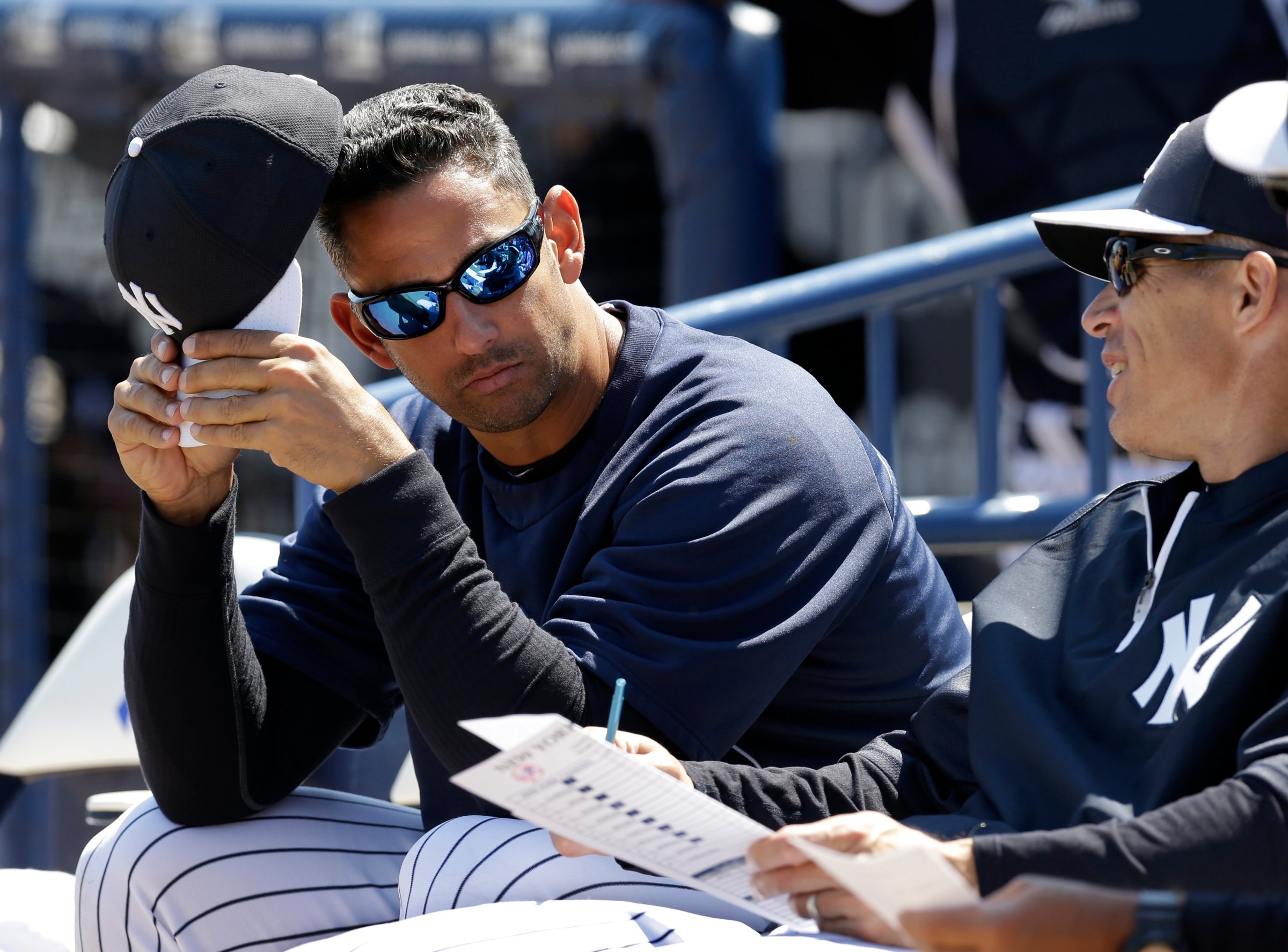 Former New York Yankees catcher Jorge Posada, left, in camp as a guest instructor, sits with New York Yankees manager Joe Girardi before a spring training baseball game against the Miami Marlins in Tampa