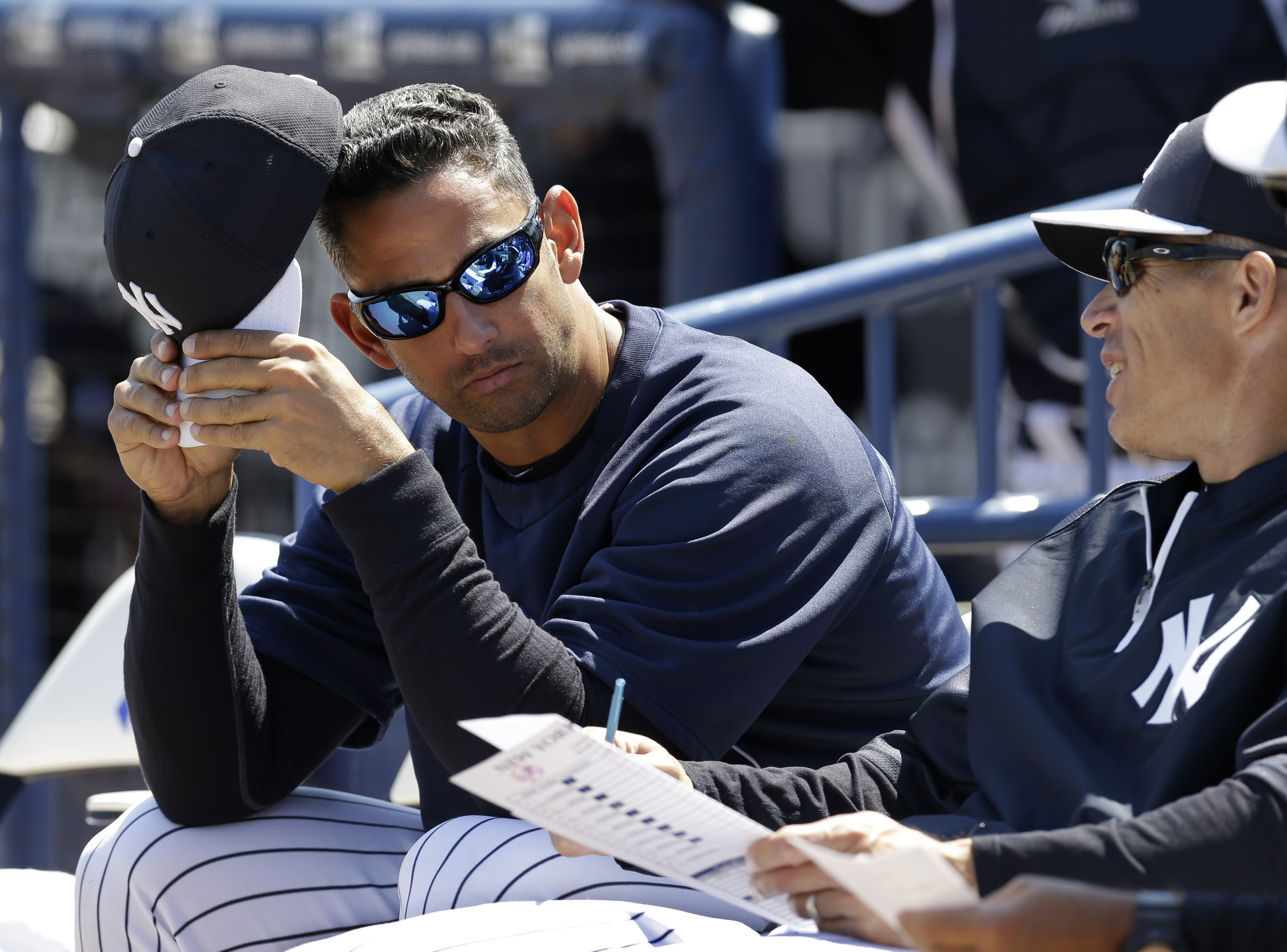 Former New York Yankees catcher Jorge Posada, left, in camp as a guest instructor, sits with New York Yankees manager Joe Girardi before a spring training baseball game against the Miami Marlins in Tampa, on March 15, 2013. (Kathy Willens—AP)