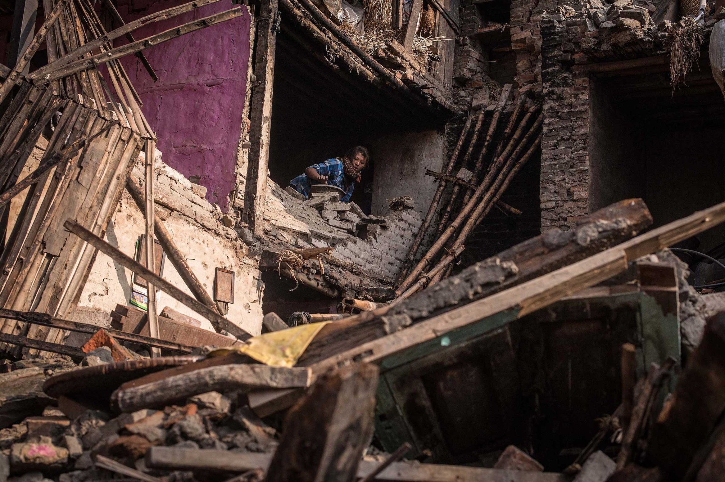 A victim of the earthquake searches for her belongings among debris of her house on in Bhaktapur, Nepal on April 29, 2015.