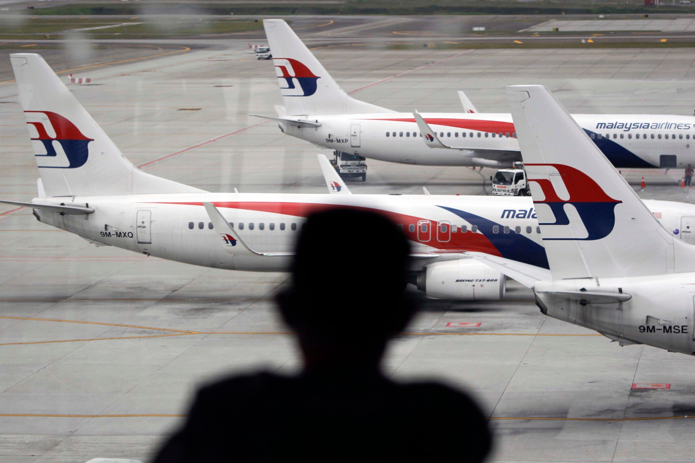 A man views a fleet of Malaysia Airline planes on the tarmac of the Kuala Lumpur International Airport, in Malaysia, Thursday, Jan. 29, 2015.