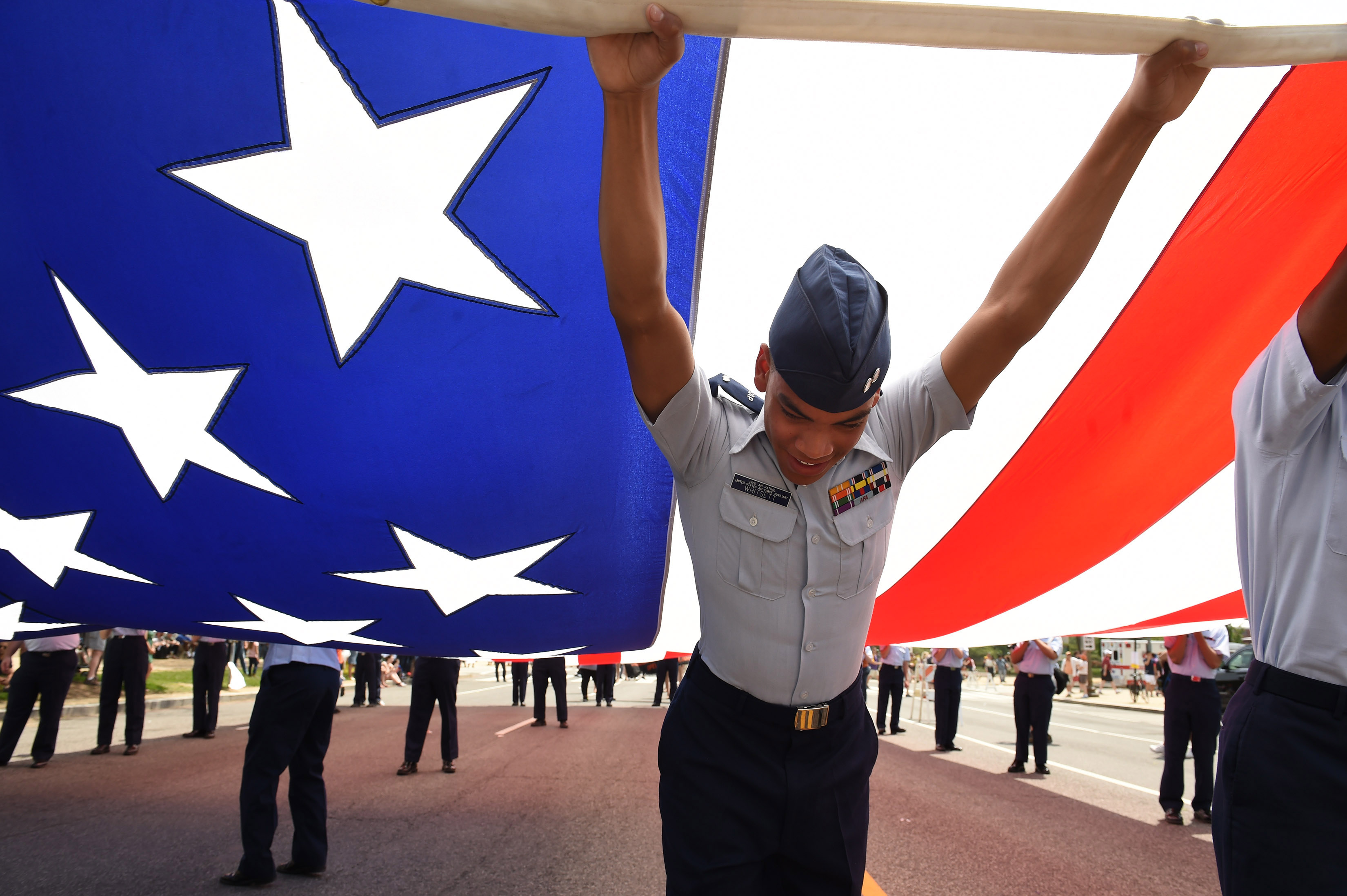 Tyler Whitsett, a First Lieutenant cadet with the Civil Air Patrol United States Air Force Auxiliary helps to hold up a large American flag prior to the start of the National Memorial Day Parade on May 25, 2015 in Washington, DC. (Matt McClain—The Washington Post/Getty Images)