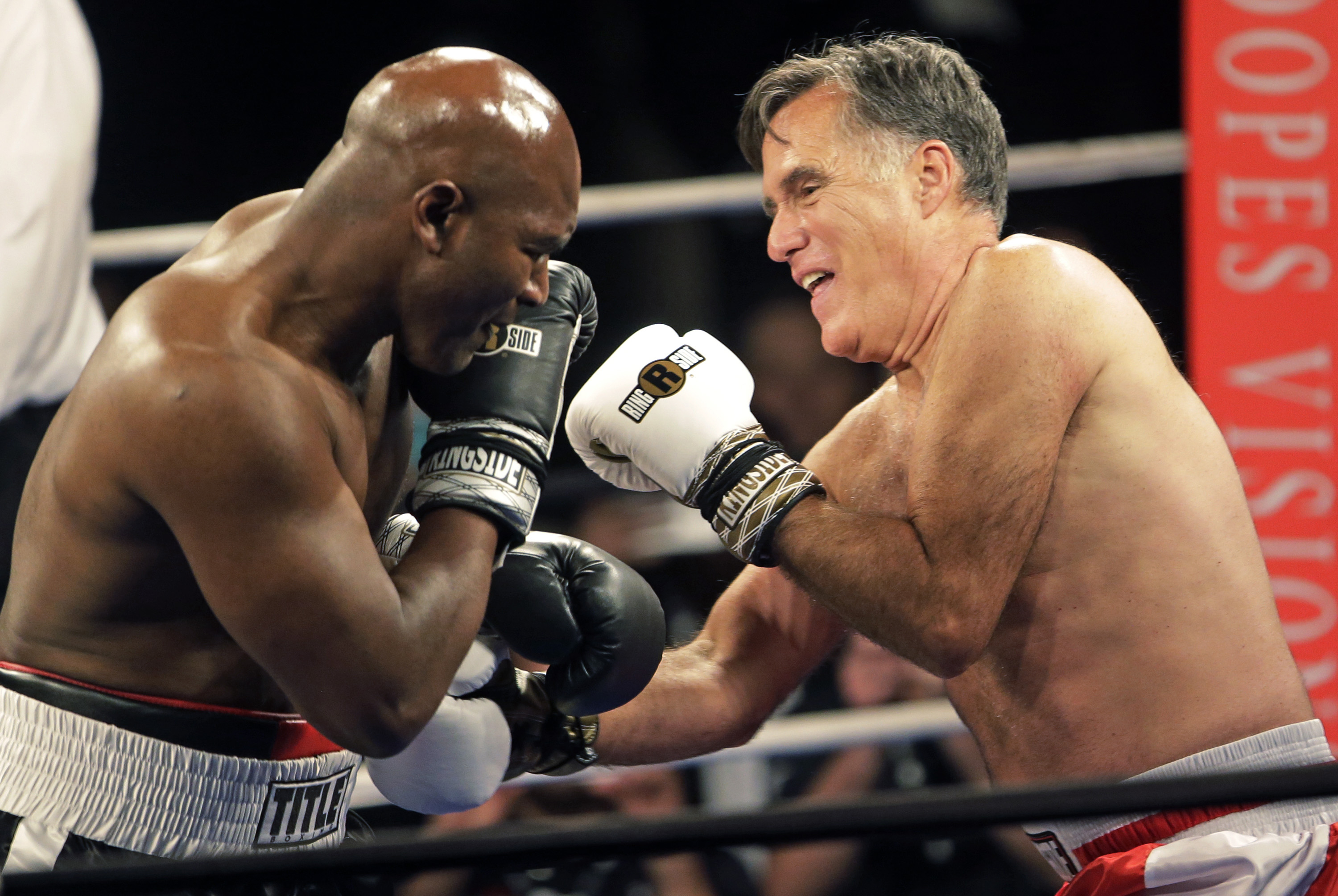 Former Republican presidential candidate Mitt Romney, right, throws punches with five-time heavyweight boxing champion Evander Holyfield at a charity fight night event on May 15, 2015, in Salt Lake City.