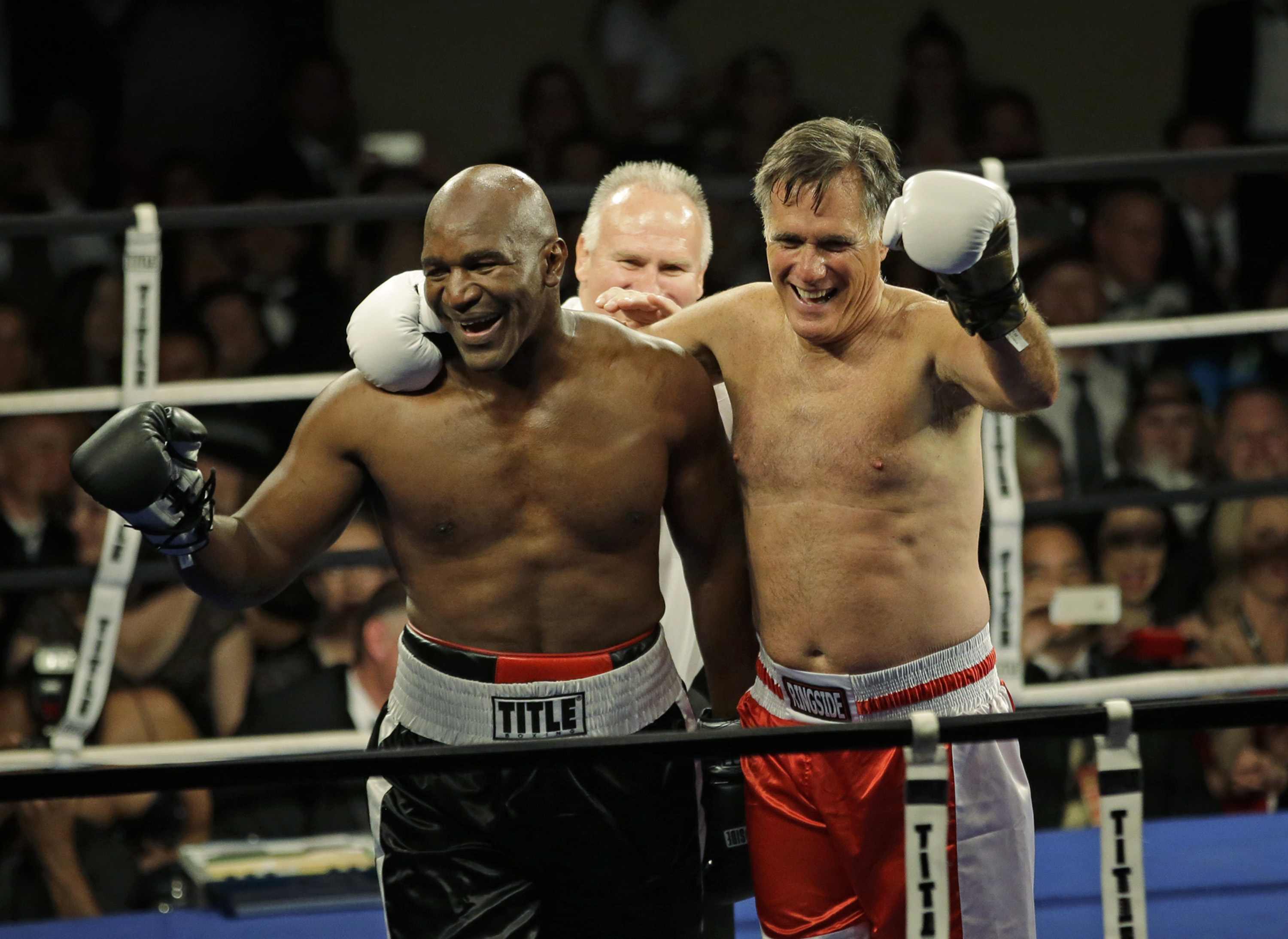 Former Republican presidential candidate Mitt Romney, right, celebrates with five-time heavyweight boxing champion Evander Holyfield following a charity fight night event on May 15, 2015, in Salt Lake City.