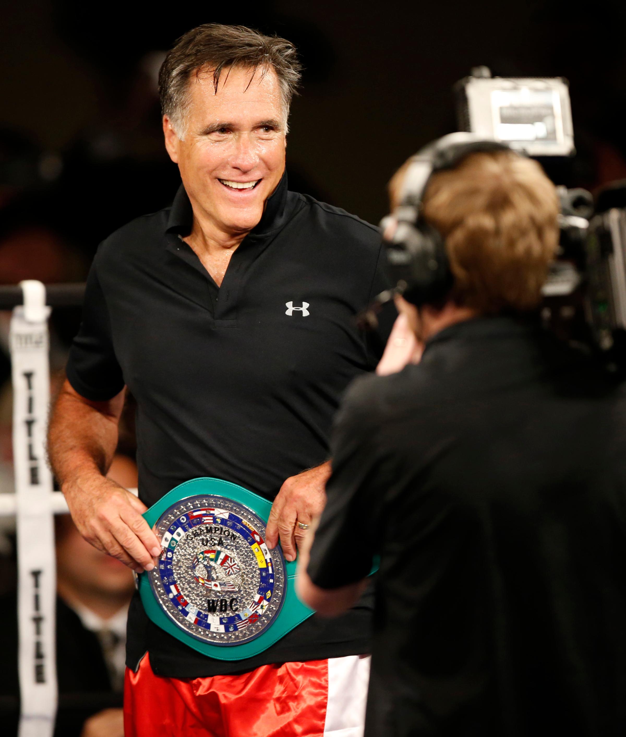 Mitt Romney shows off his boxing belt after a fight with Evander Holyfield during a charity boxing event on May 15, 2015 in Salt Lake City.