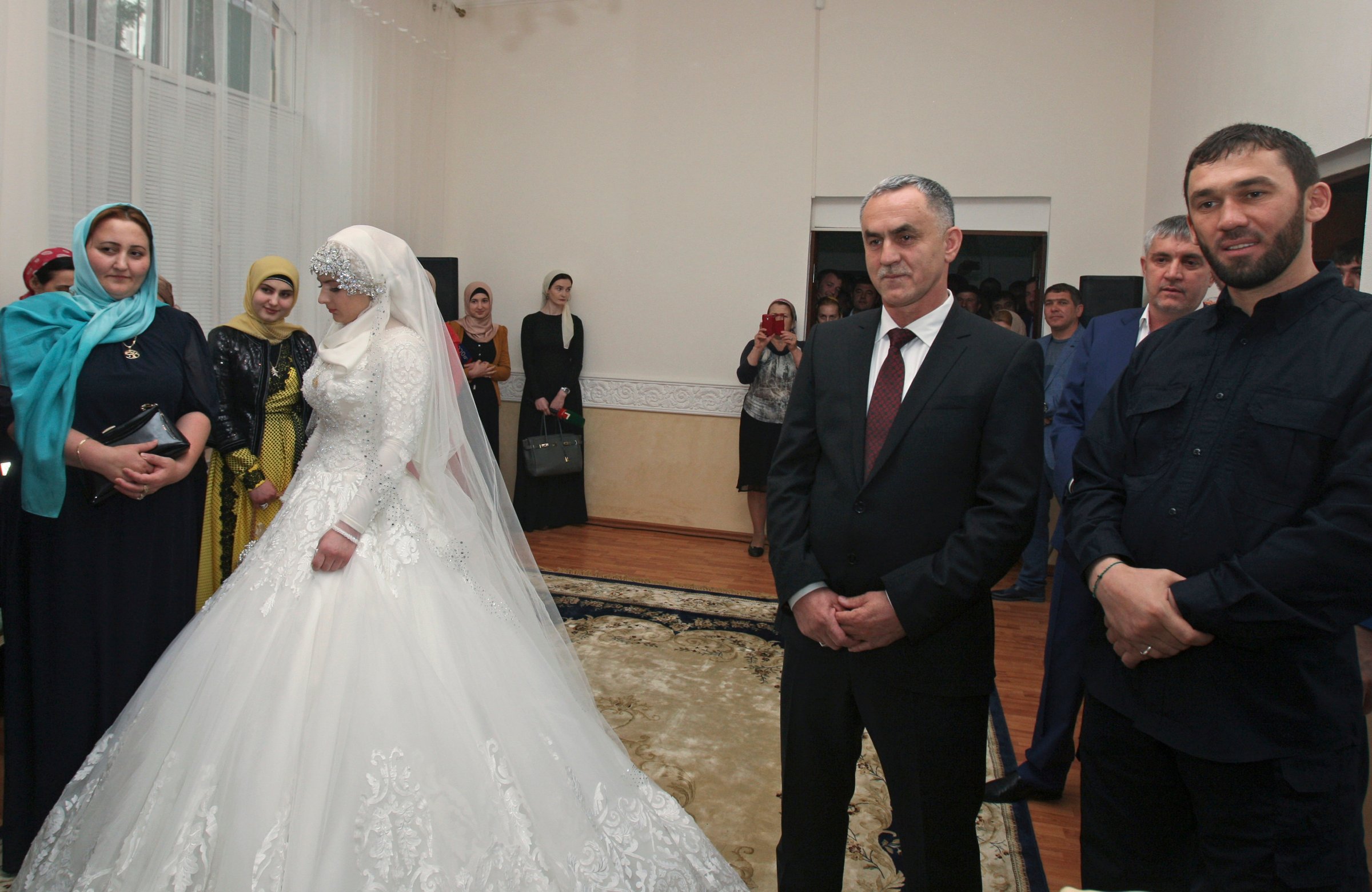 Bride, Chechen Kheda Goilabiyeva, and fiancé, Chechen police officer Nazhud Guchigov, second right, stand in a wedding registry office in Chechnya's provincial capital Grozny, Russia