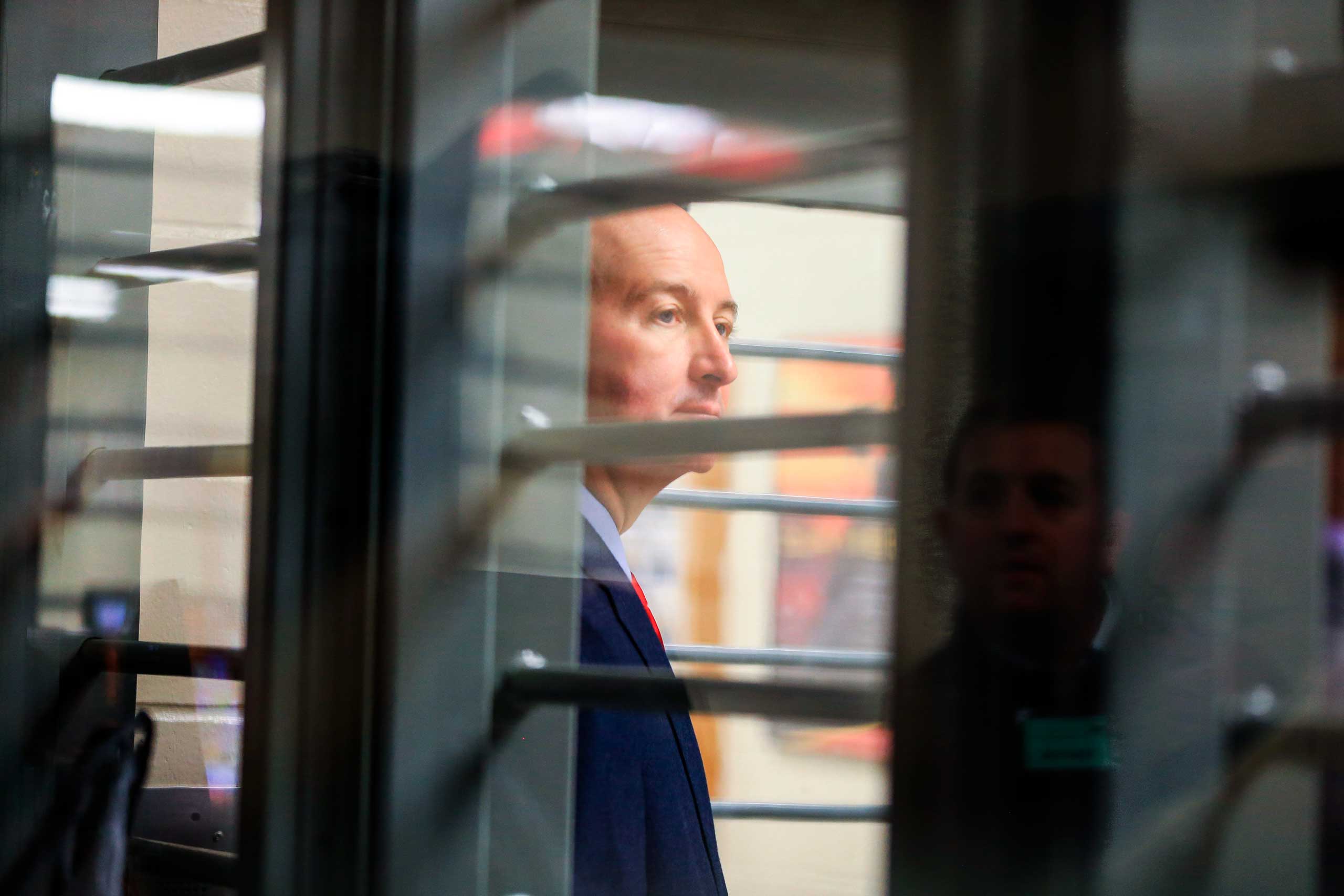 Nebraska Gov. Pete Ricketts is seen through bars during a tour of the Tecumseh State Correctional Institution in Tecumseh, Neb., on May 19, 2015.