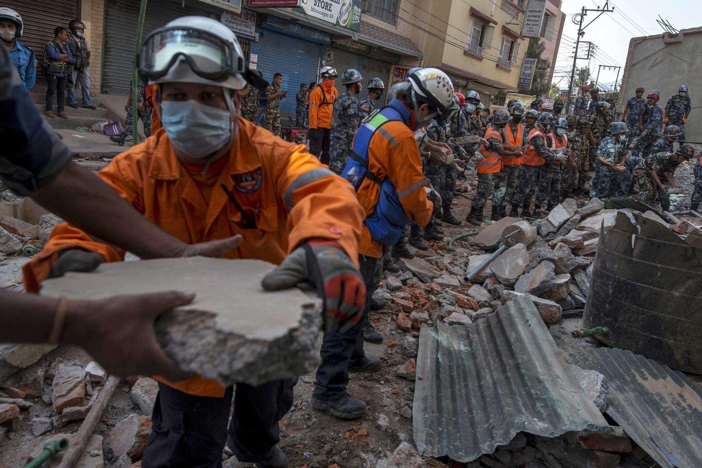 Nepalese military personnel remove debris in search of survivors after a fresh 7.3 earthquake struck, in Kathmandu on May 12, 2015.