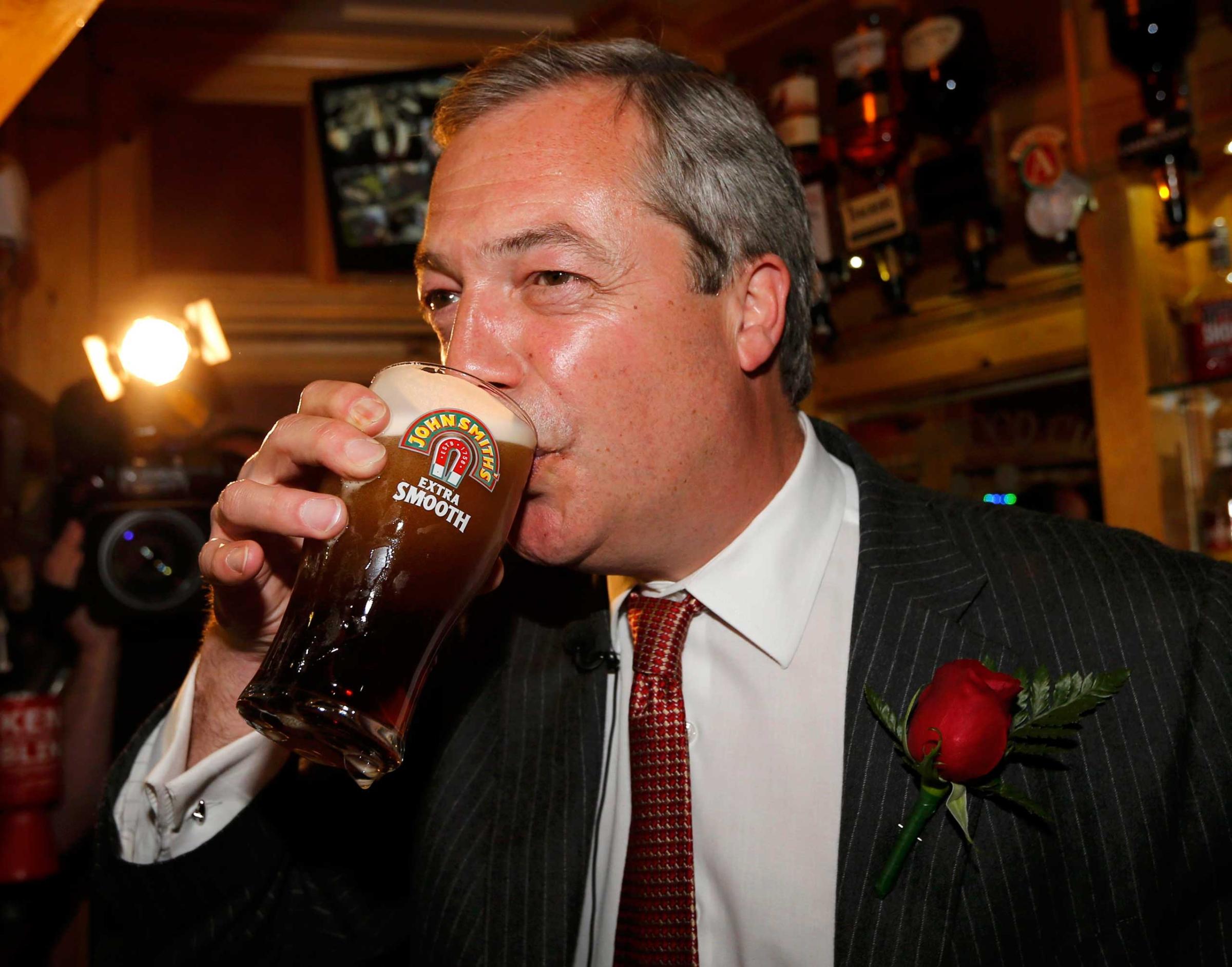 Nigel Farage enjoys a pint of beer during a visit to mark St George's day at the Northwood Club in Ramsgate, southern England on April 23, 2015.