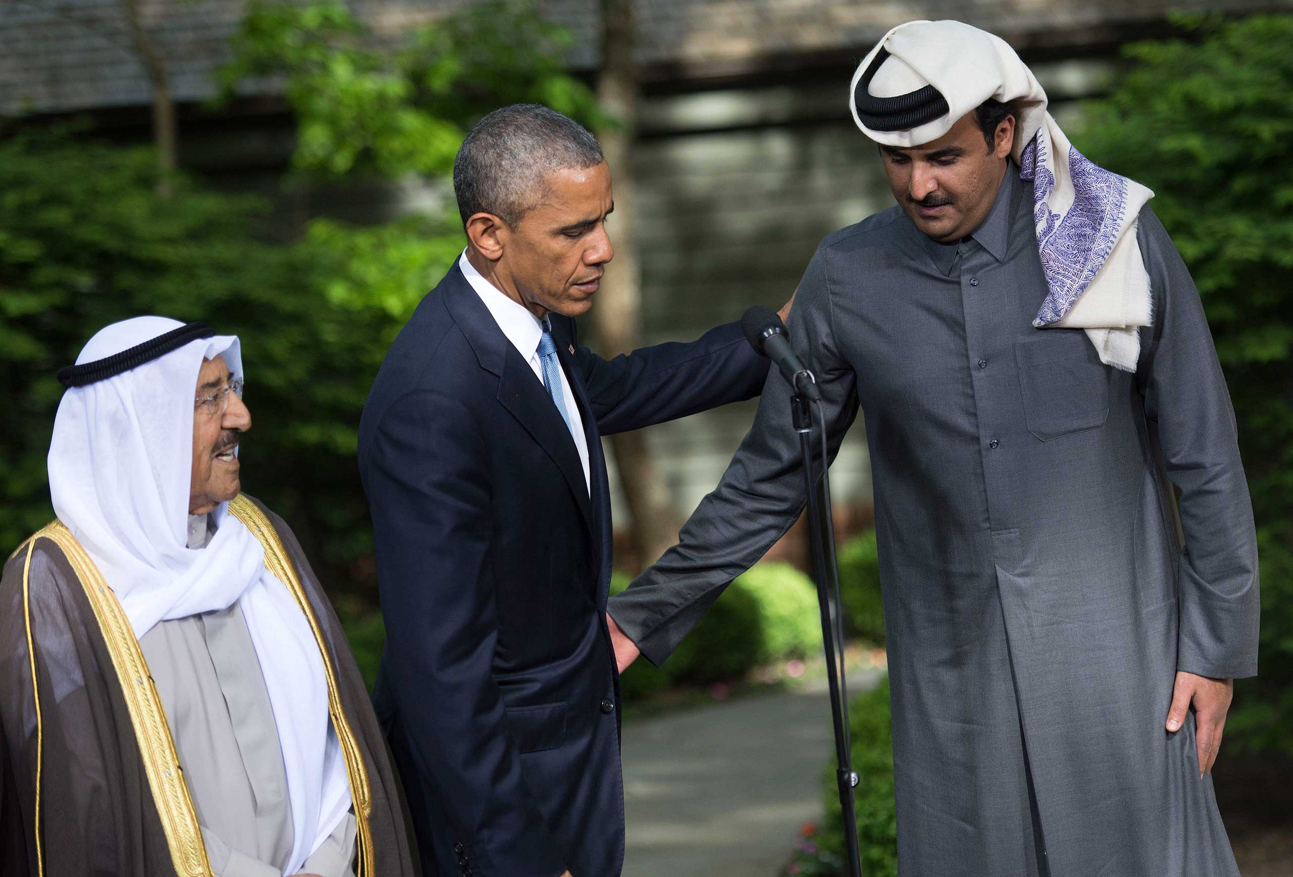Obama encourages Kuwaiti Emir Sheikh Sabah Al-Ahmad Al-Sabah to make a statement alongside Qatar's Emir Sheikh Tamim bin Hamad Al-Thani, following the Gulf Cooperation Council-U.S. summit at Camp David on May 14, 2015. (Kevin Dietsch—AP)