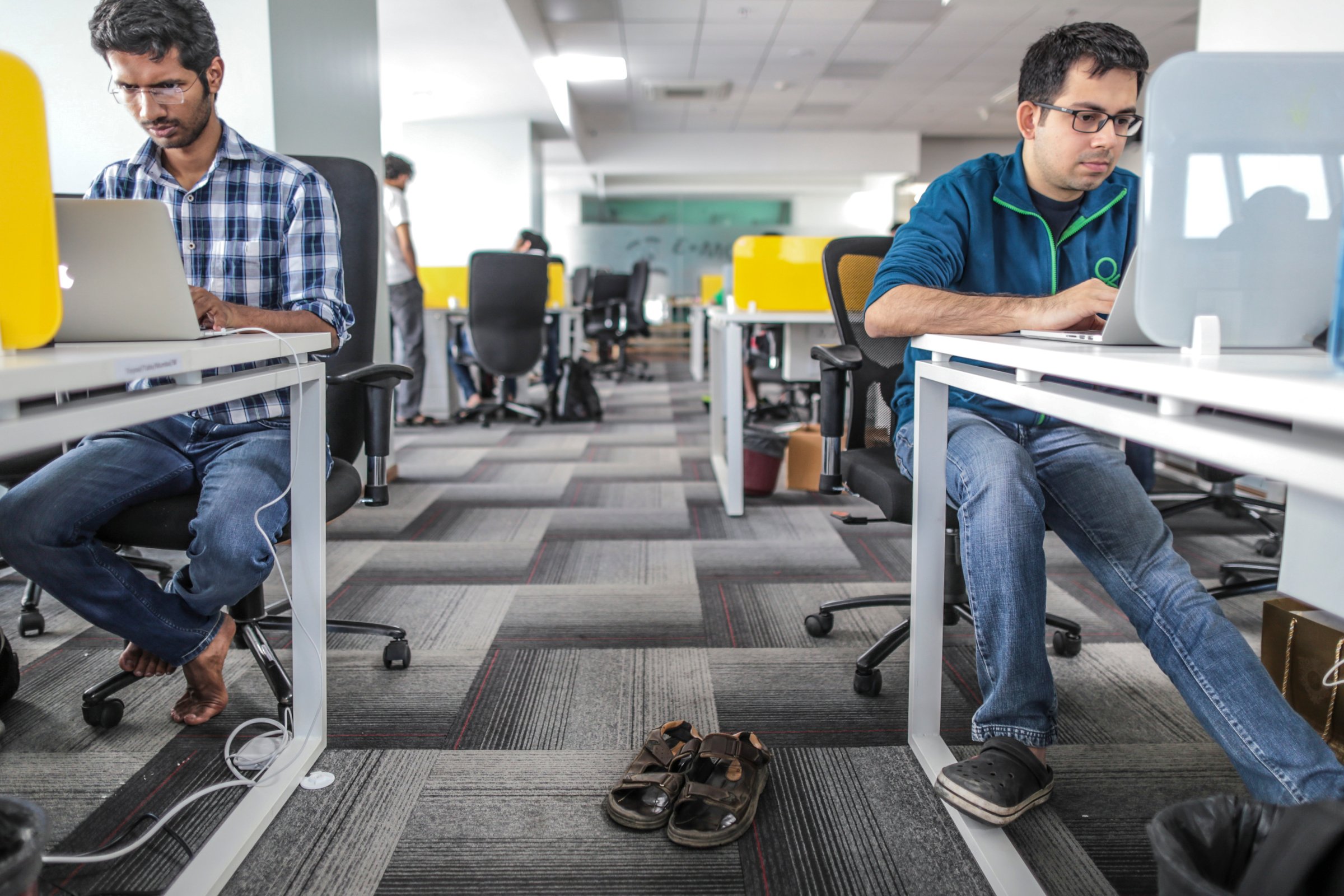 Tiny Owl employees work on laptop computers as pair of sandals sit on the floor inside the company's head office in Mumbai, India, on Monday, March. 9, 2015.