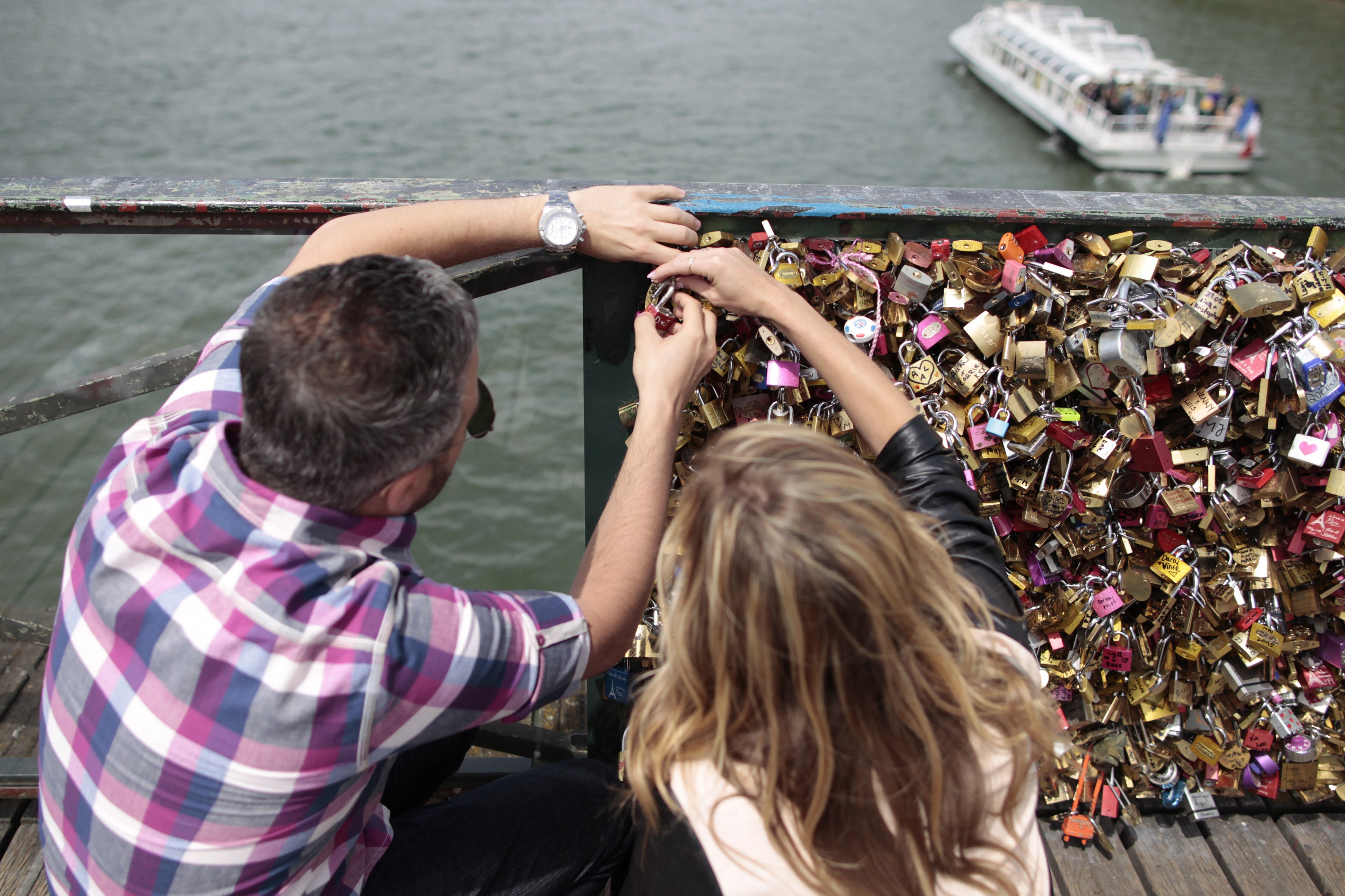 A couple locks a padlock on the Pont des Arts on May 29, 2015, in Paris as the Paris municipality announced that the bridge's fences have to be removed due to the weight of the padlocks put by tourists to symbolize everlasting love (Charly Triballeau—AFP/Getty Images)