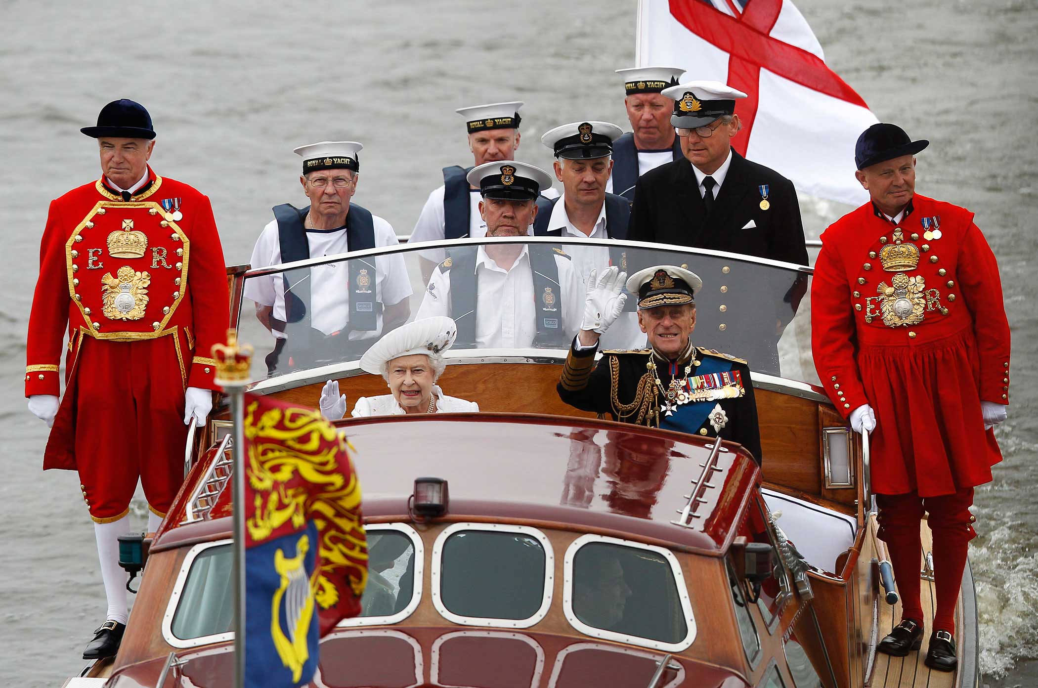 Queen Elizabeth and Prince Philip wave from a boat during a pageant in celebration of the Queen's Diamond Jubilee along the River Thames in central London on June 3, 2012.