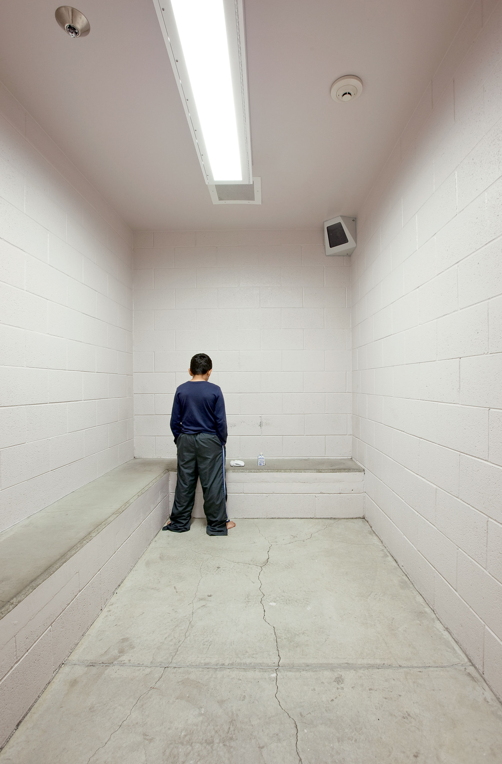 Washoe County Detention Facility, Reno, Nevada.BASICS: Built in 2004 for a capacity of 108, all are pre-adjudicated. The facility holds youth for up to 30 days before transferring them to commitment. PICTURED: R, age 10, a 5th grader, brought in from school by a policeman. He seemed tiny and timid, standing barefoot in oversized warm-up pants and a sweatshirt. He was waiting to be picked up by his mom, who couldn't come get him until she got off work, for fear of losing her job. He is checked on every five minutes. He stabbed a schoolmate- but it is unclear what the tool was, pencil, knife, fork... The Director of the facility tells me that one principal had an 8-year-old brought in for swiping a bagel off his desk. The director says, this is not the place for these offenses.
