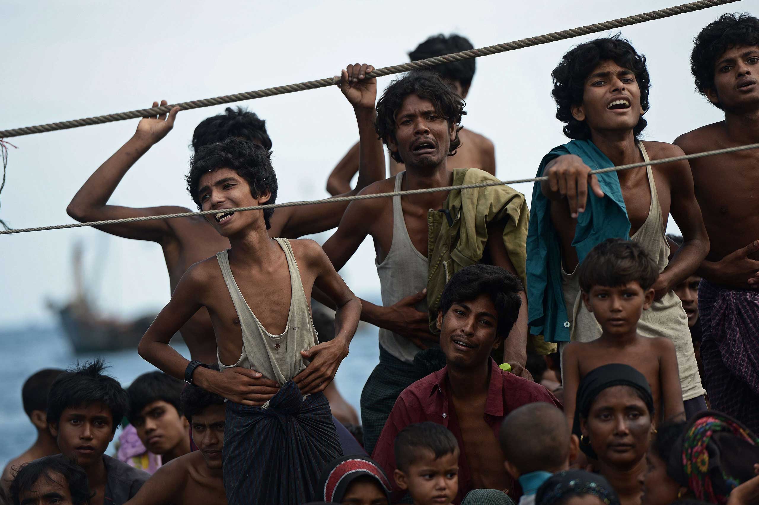 Rohingya migrants stand and sit on a boat drifting in Thai waters off the southern island of Koh Lipe in the Andaman sea between Thailand and Malaysia on May 14, 2015.