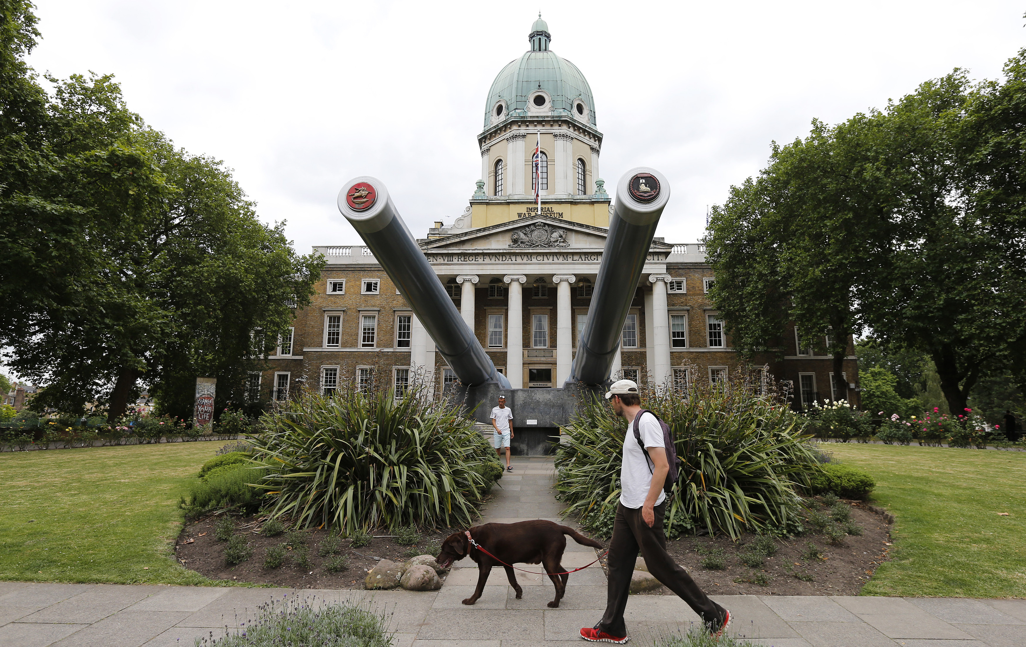 A man walks his dog past the newly re-opened Imperial War Museum in central London on July 16, 2014. (Suzanne Plunkett —Reuters)