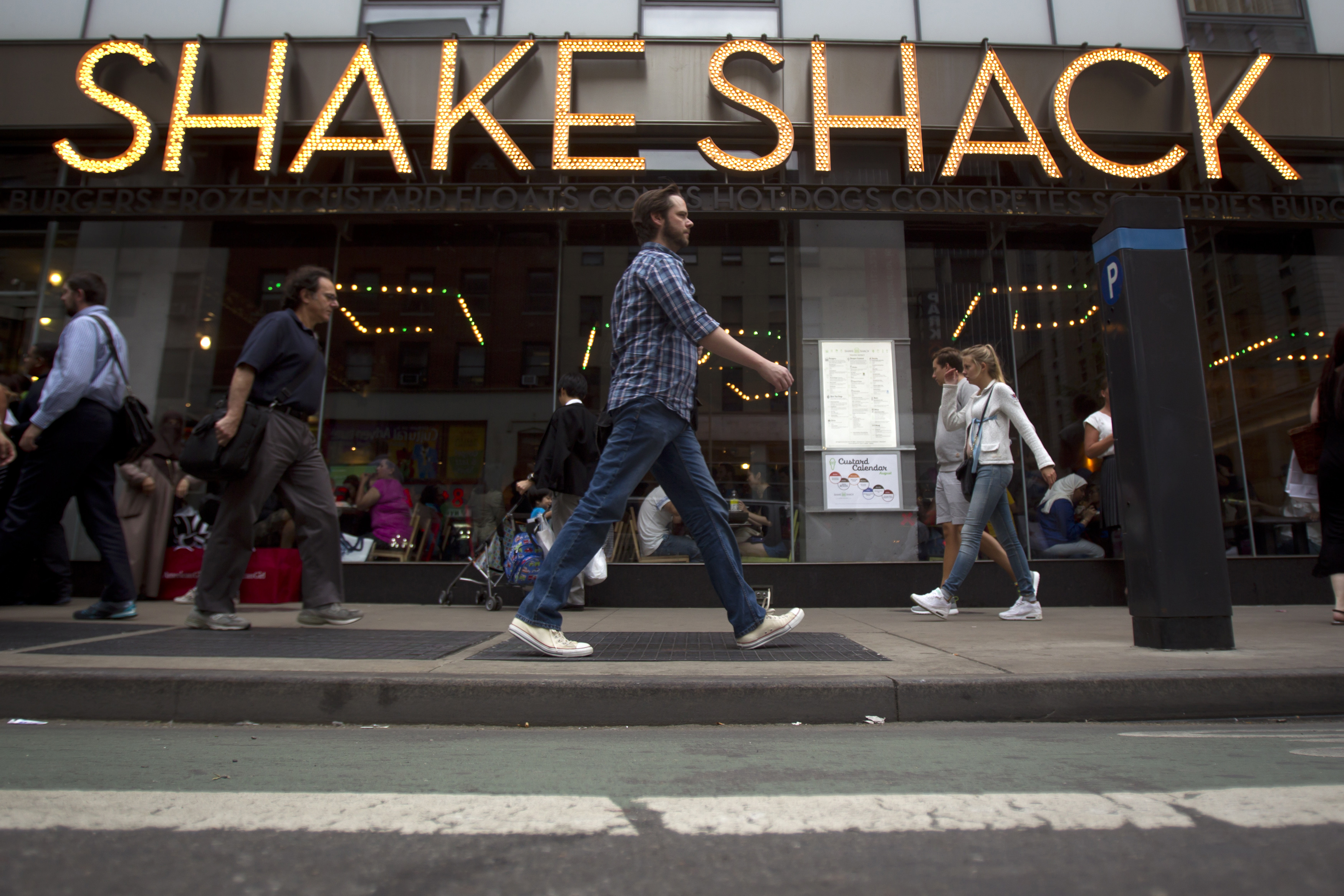People walk past a Shake Shack restaurant in New York
