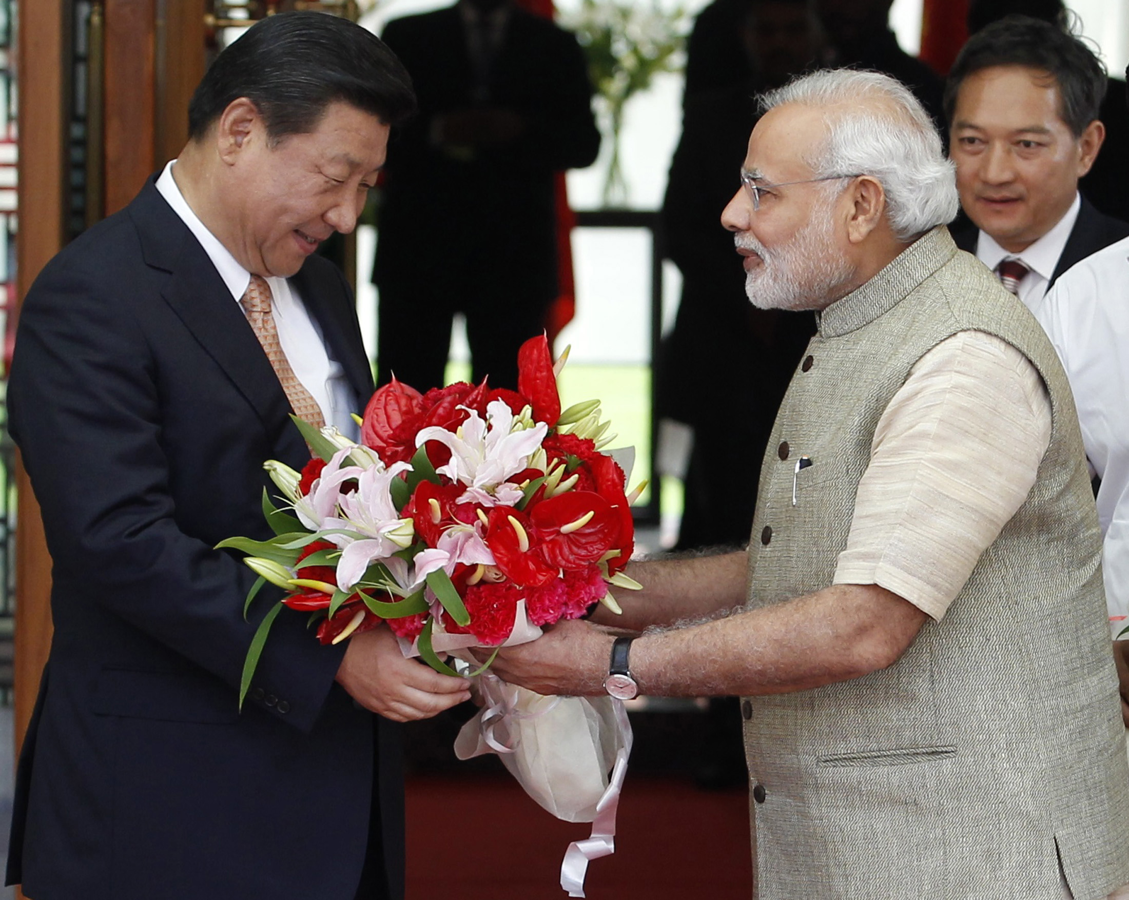 India's PM Modi presents a bouquet to China's President Xi before their meeting in Ahmedabad