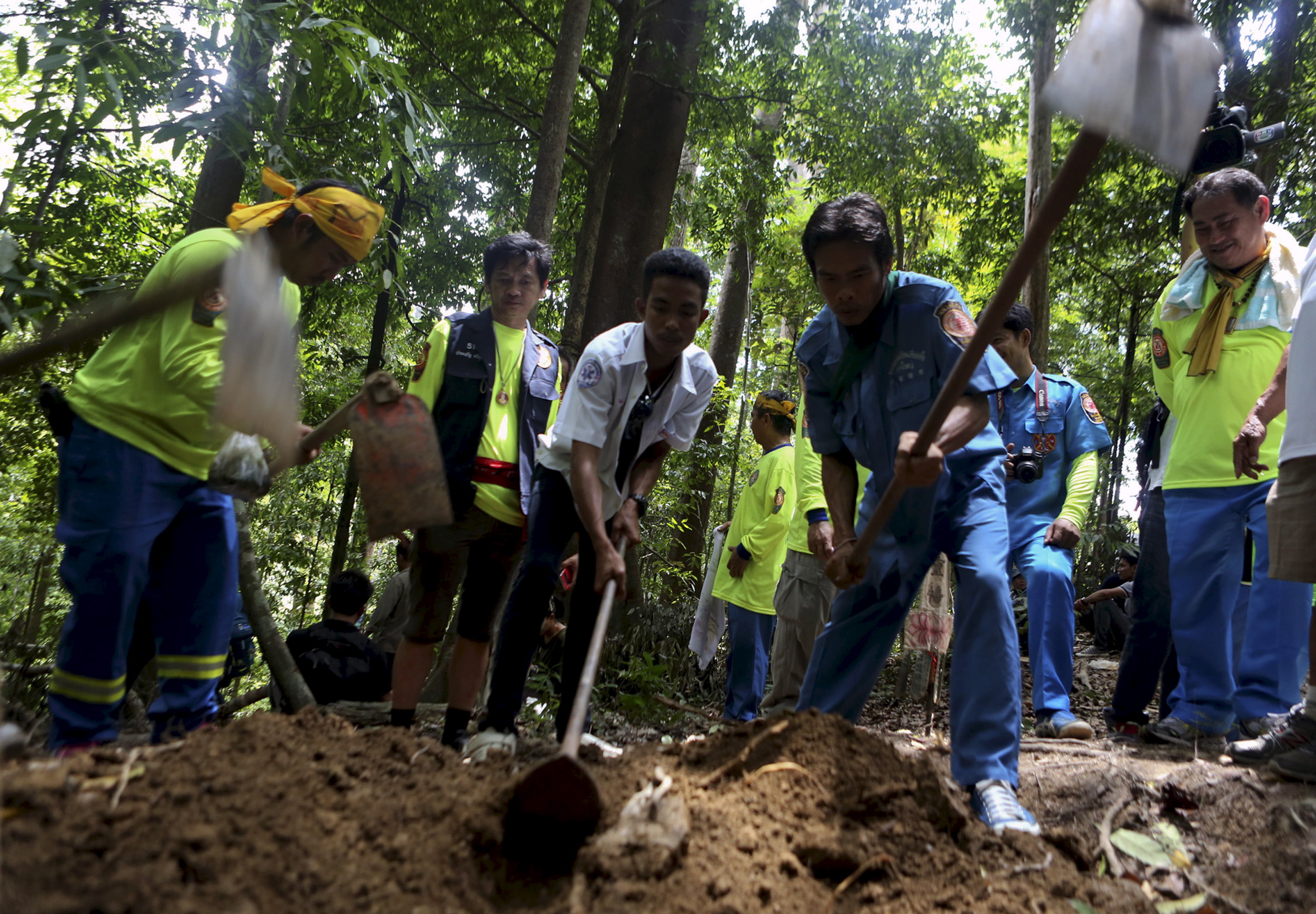 Rescue workers inspect a mass grave at an abandoned camp in a jungle in Thailand's southern Songkhla province on May 5, 2015 (Surapan Boonthamon—Reuters)